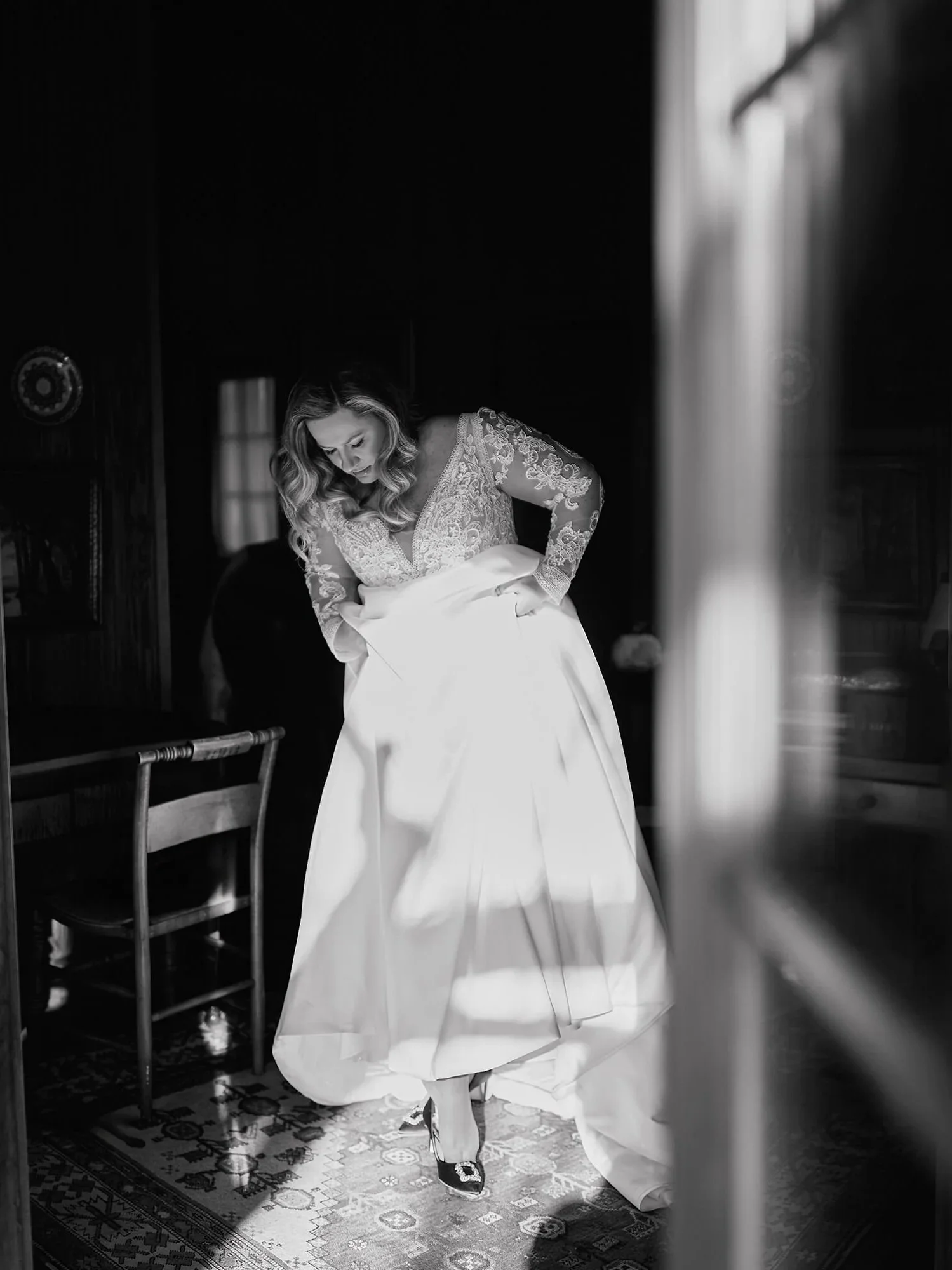 Bride getting ready by the window, soft light, black and white