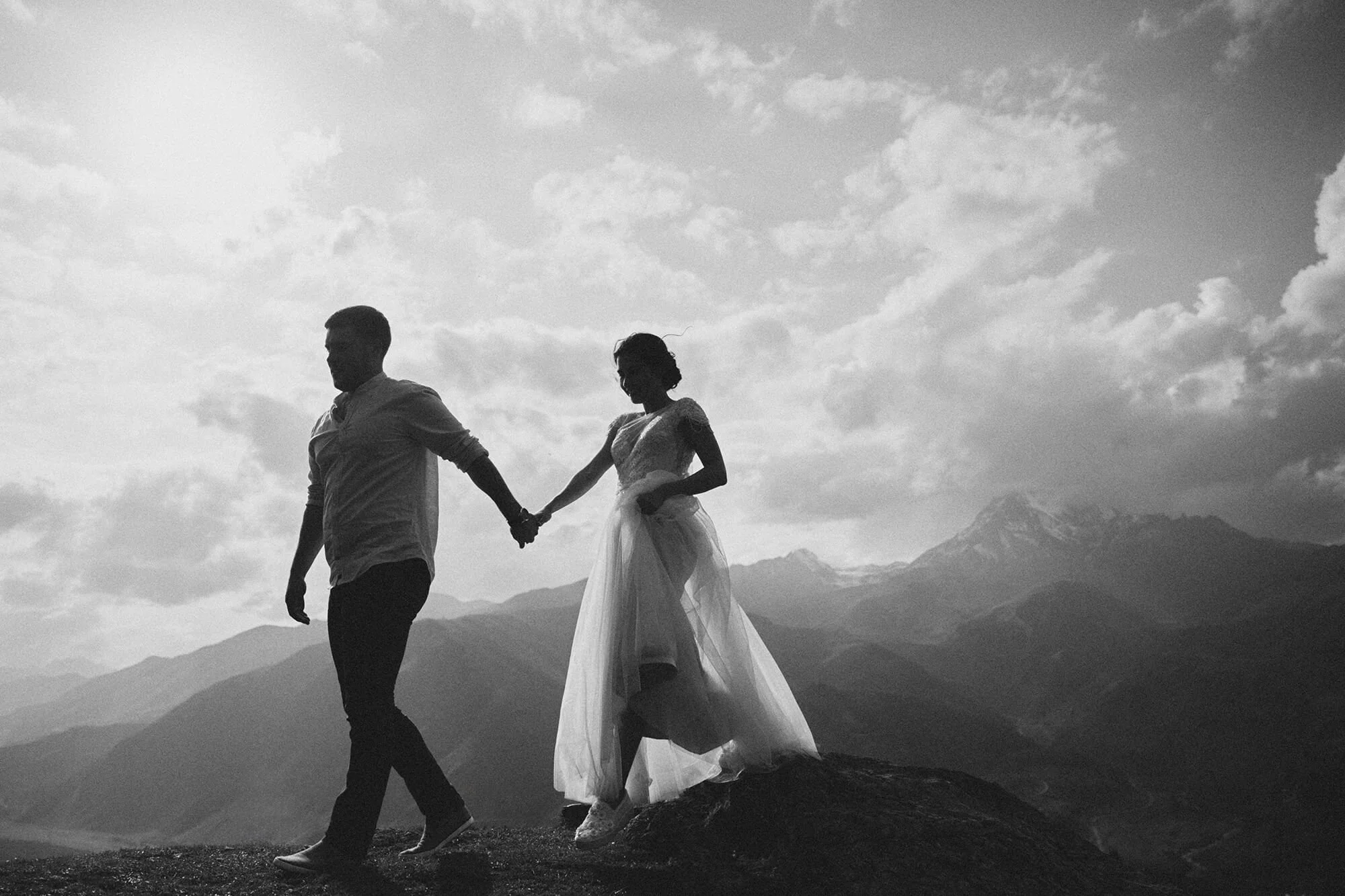 Newly engaged couple strolling with mountains in the background