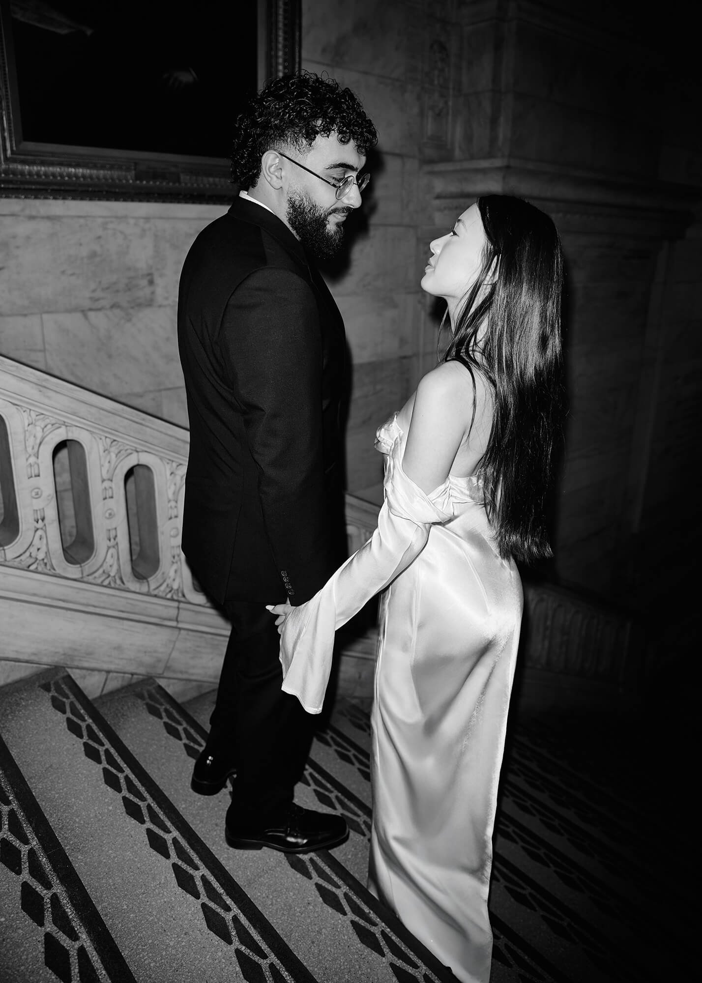 Engaged couple walking on the NYC Library stairs during their engagement session