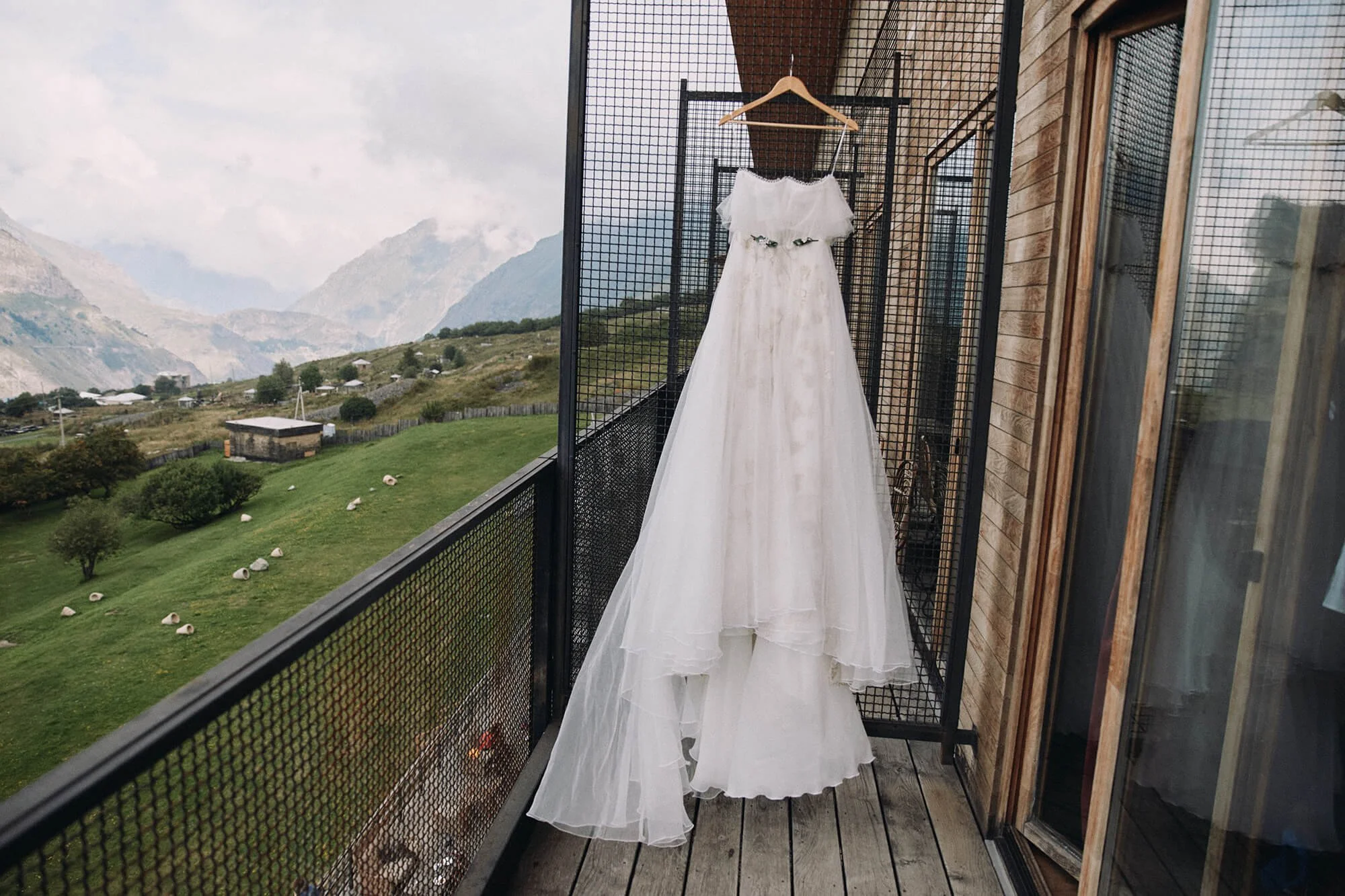 Bridal dress hanging outside wooden house