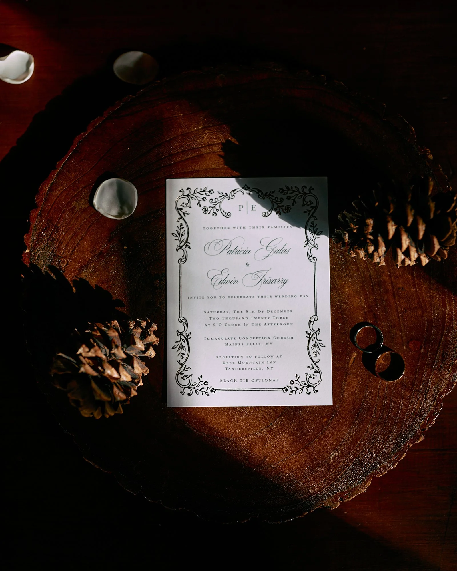 Flatlay of wedding invitation with natural tones and rings