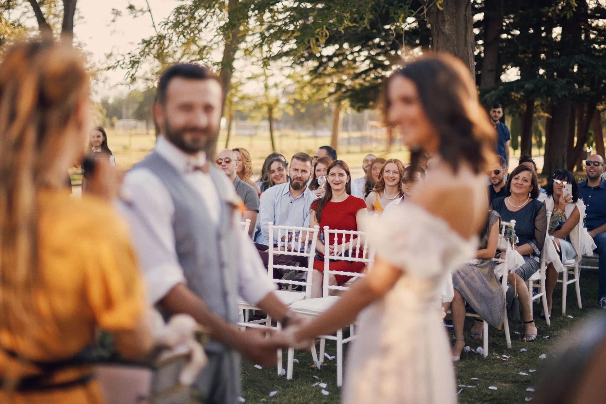 Guests watching the ceremony outdoors at sunset.