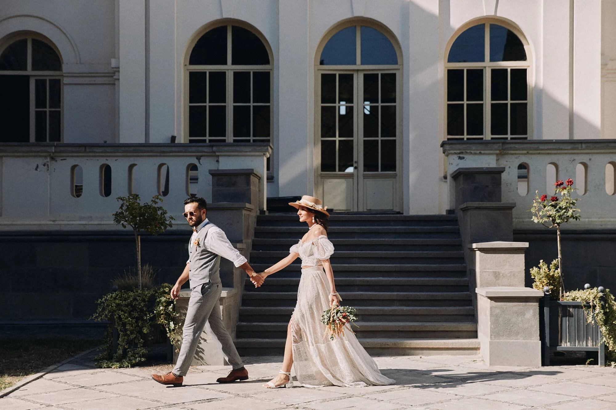 Bride and groom walking down stairs outside a grand building