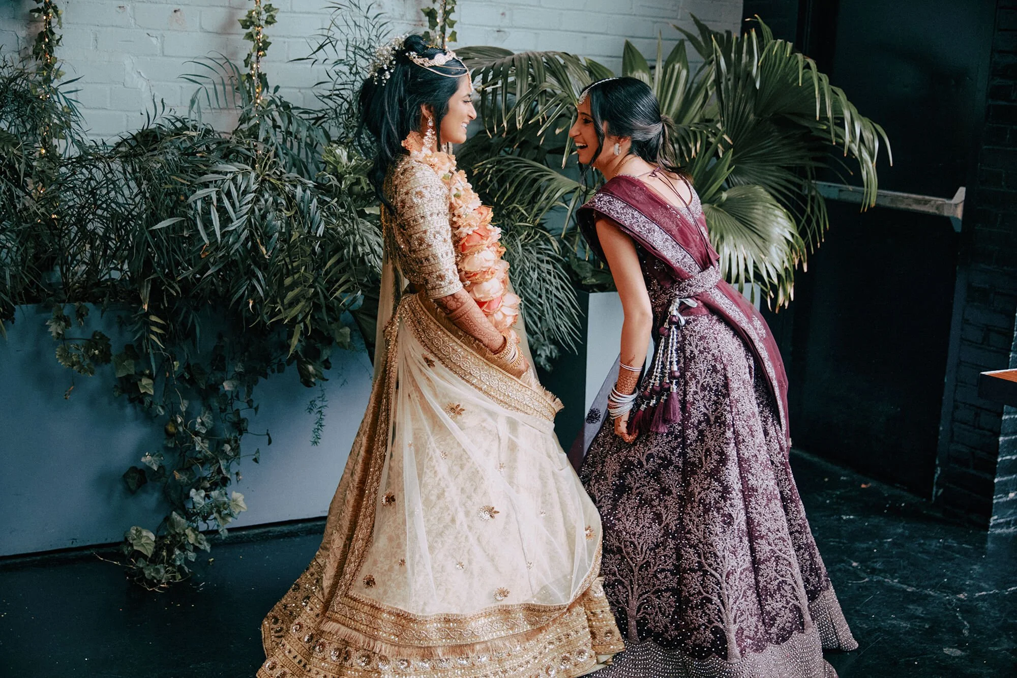 A beautiful portrait of the bride and a bridesmaid in their traditional Indian wedding attire
