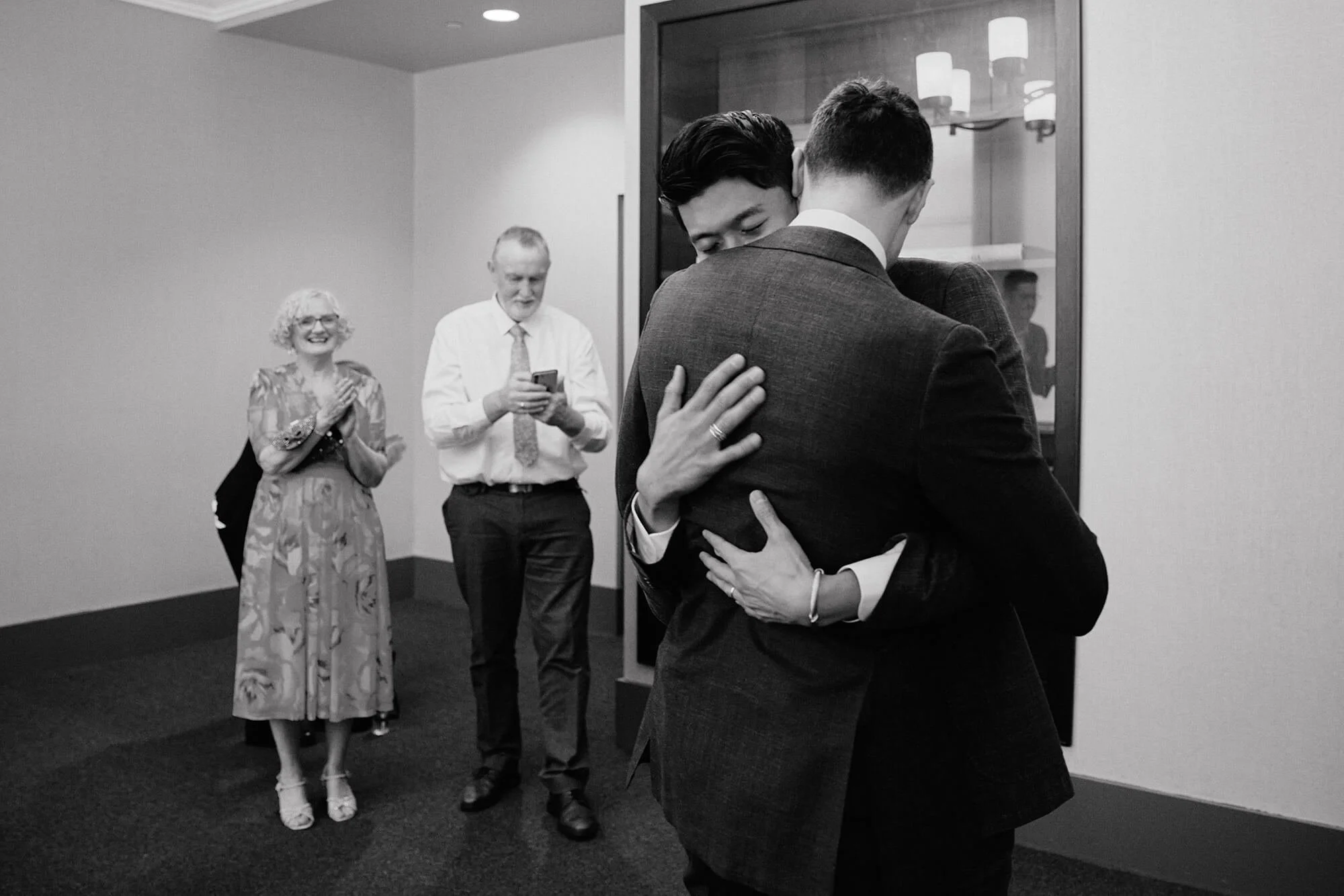 Emotional hug during City Hall ceremony with family