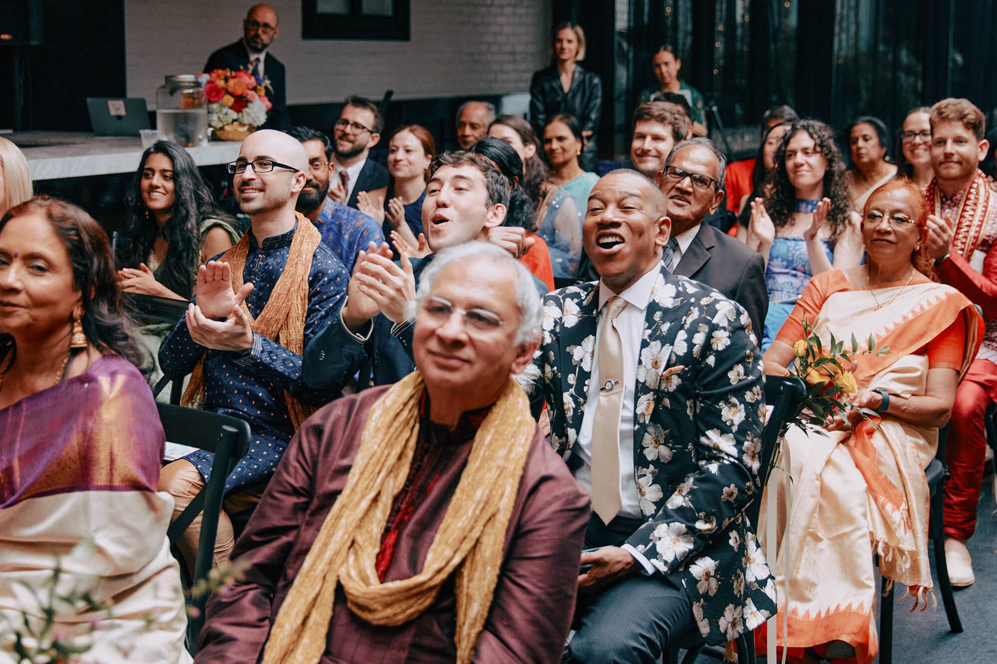 Wedding guests are watching the ceremony with joy and excitement.