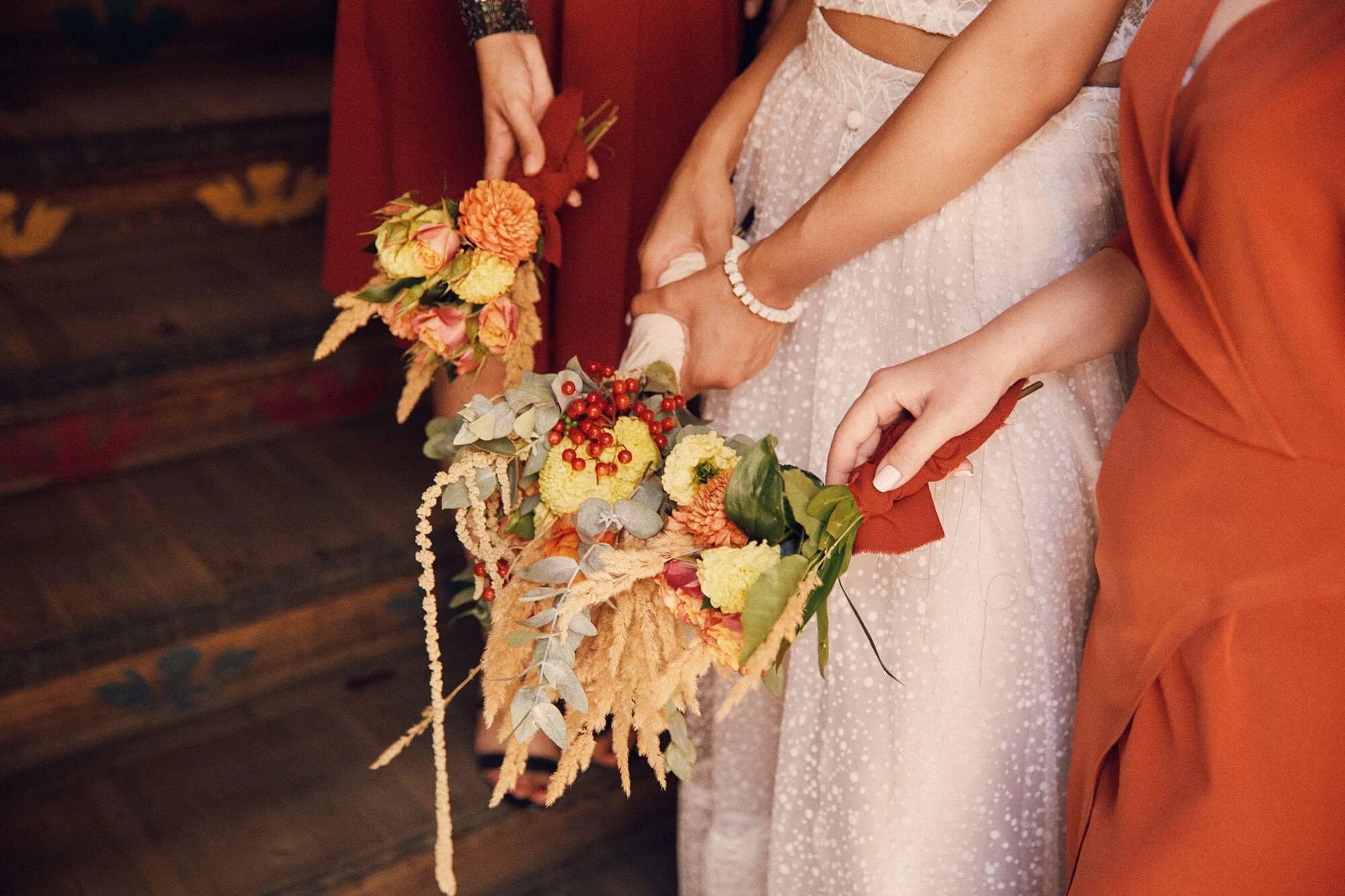 Close-up of hands holding a vibrant bouquet of flowers