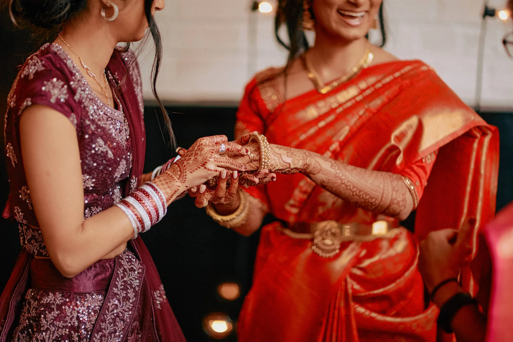 Close-up of the bride's hands with her wedding rings and traditional bangles.