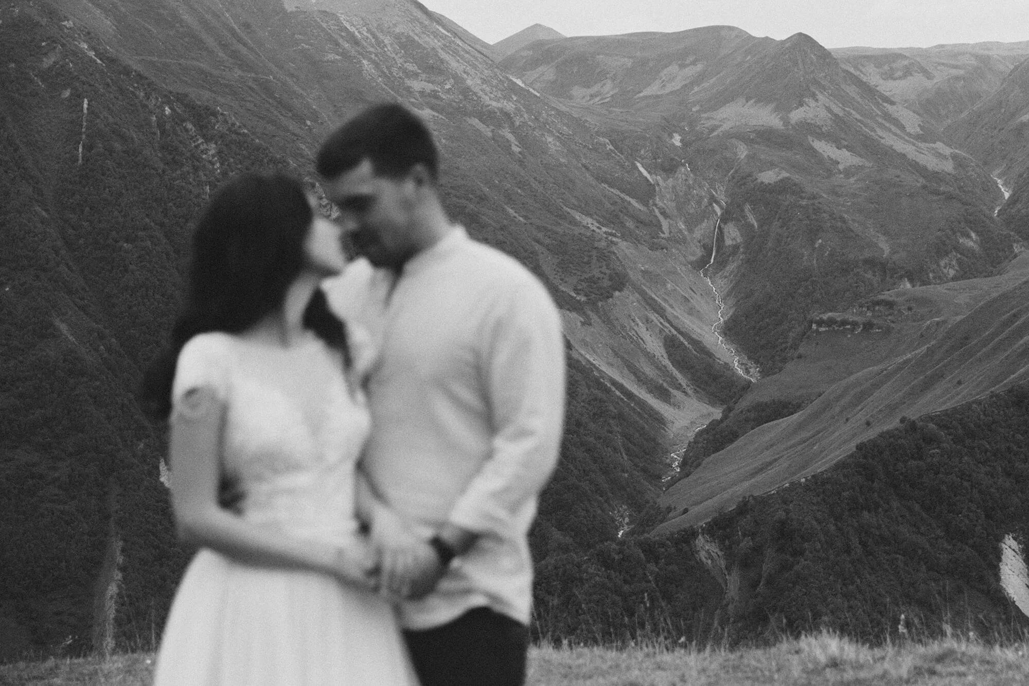 Newly engaged couple softly blurred with stunning mountain backdrop