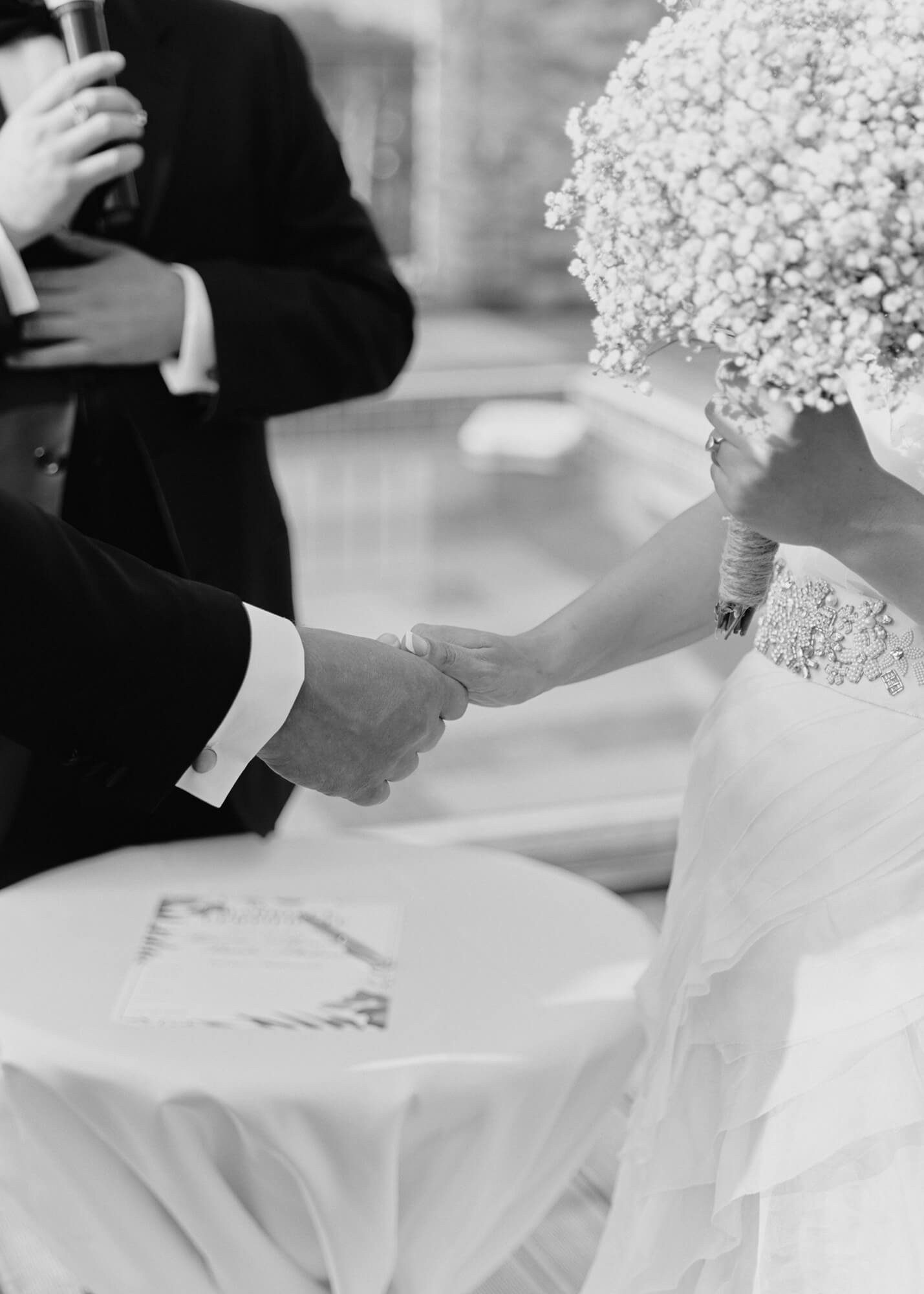 Bride and groom holding hands while exchanging vows