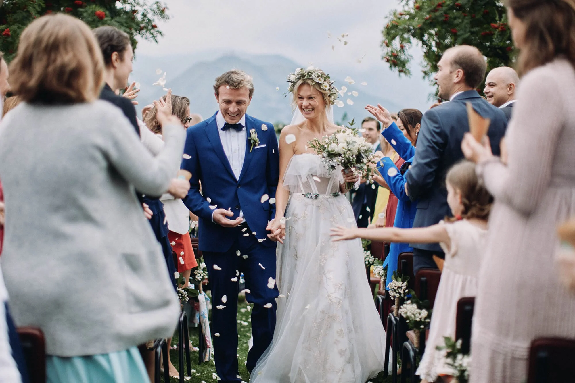 Couple walking down the aisle together gusts cheering
