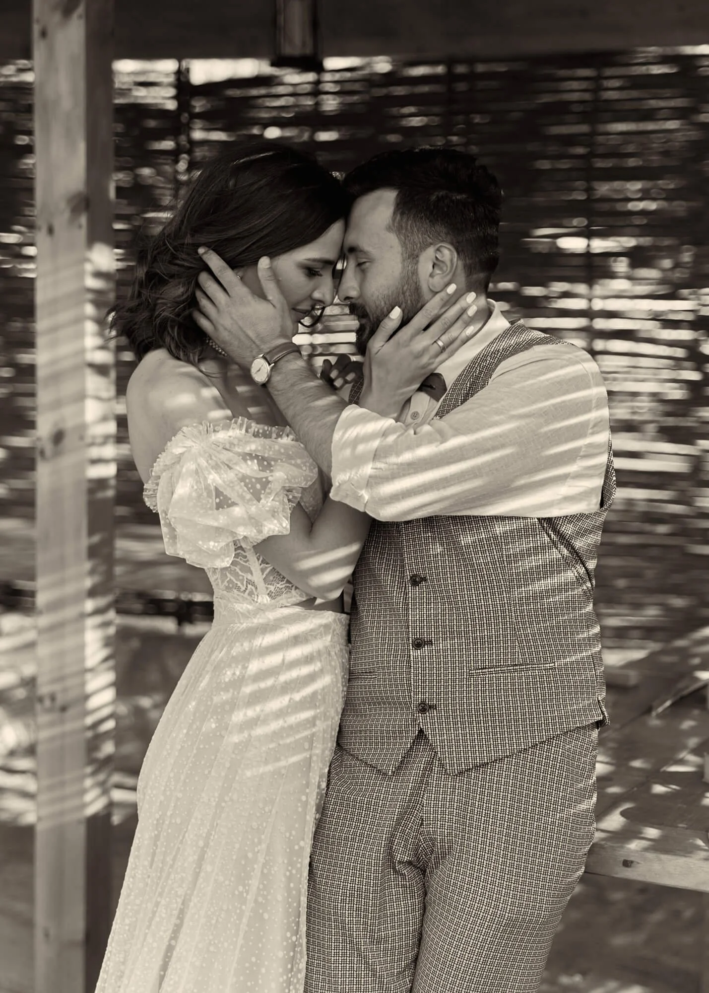 Intimate, black and white close-up of the bride and groom embracing