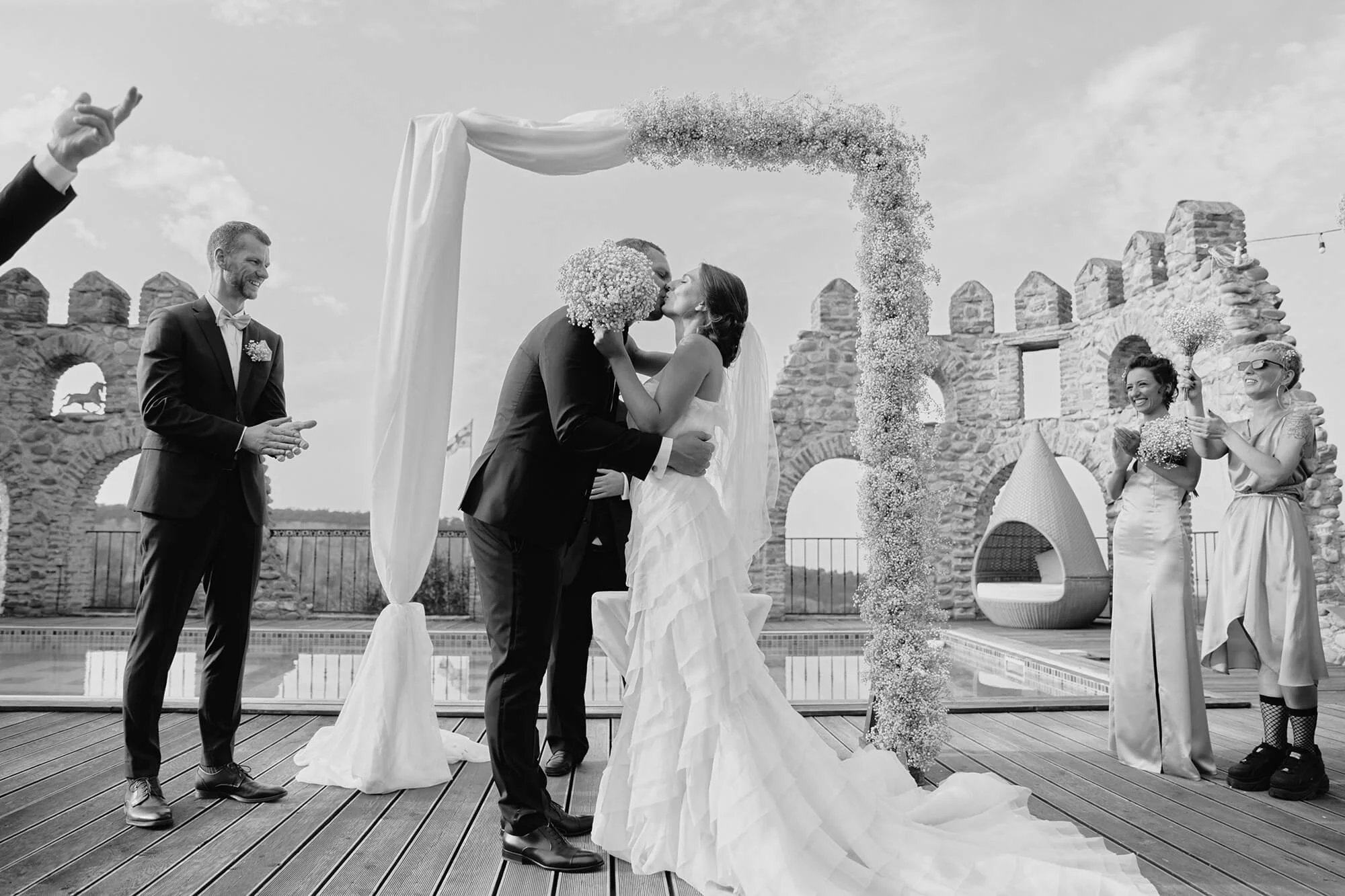 Bride and groom sharing a kiss under the ceremony arch