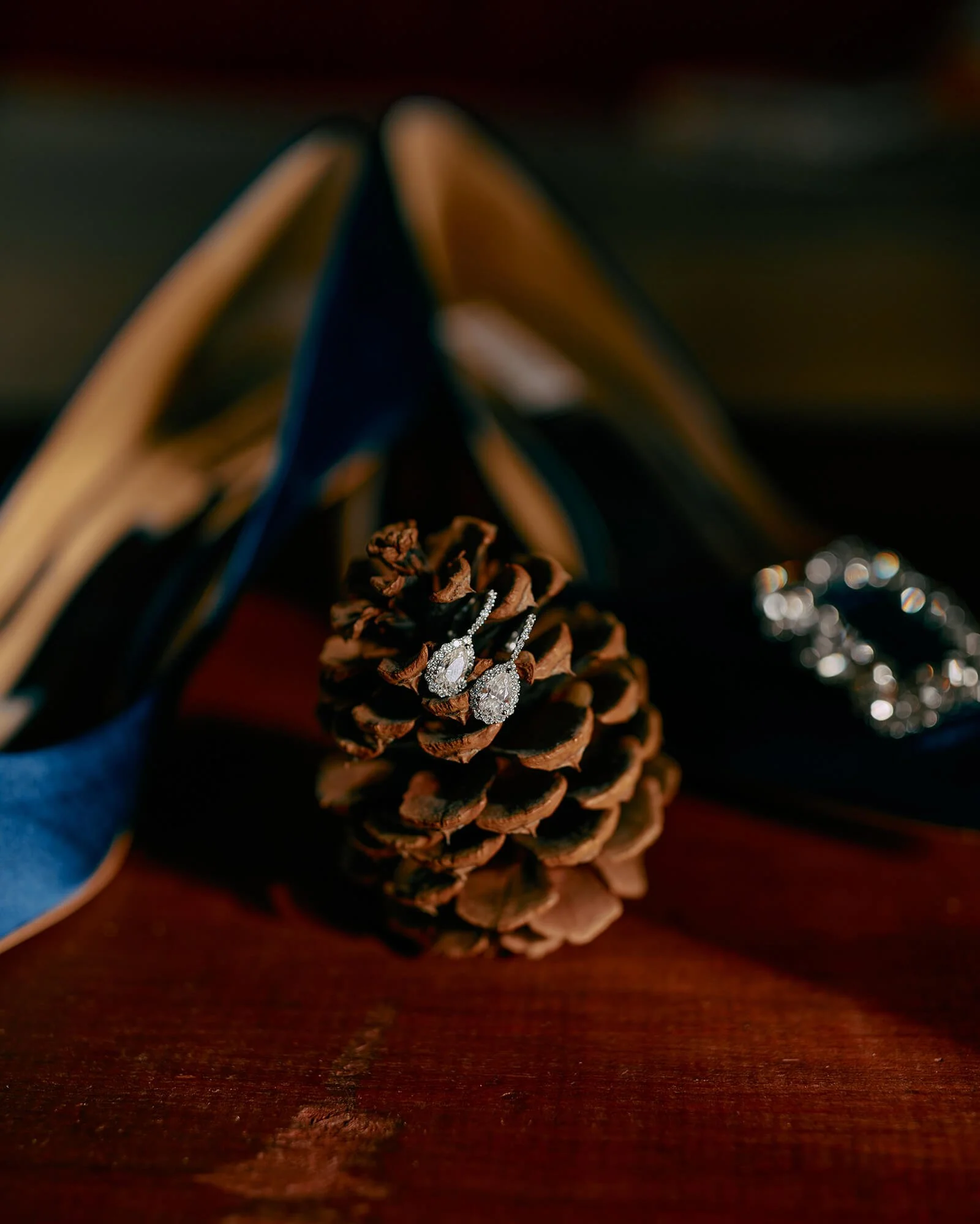 Bridal earrings and shoes resting on a cozy wooden table