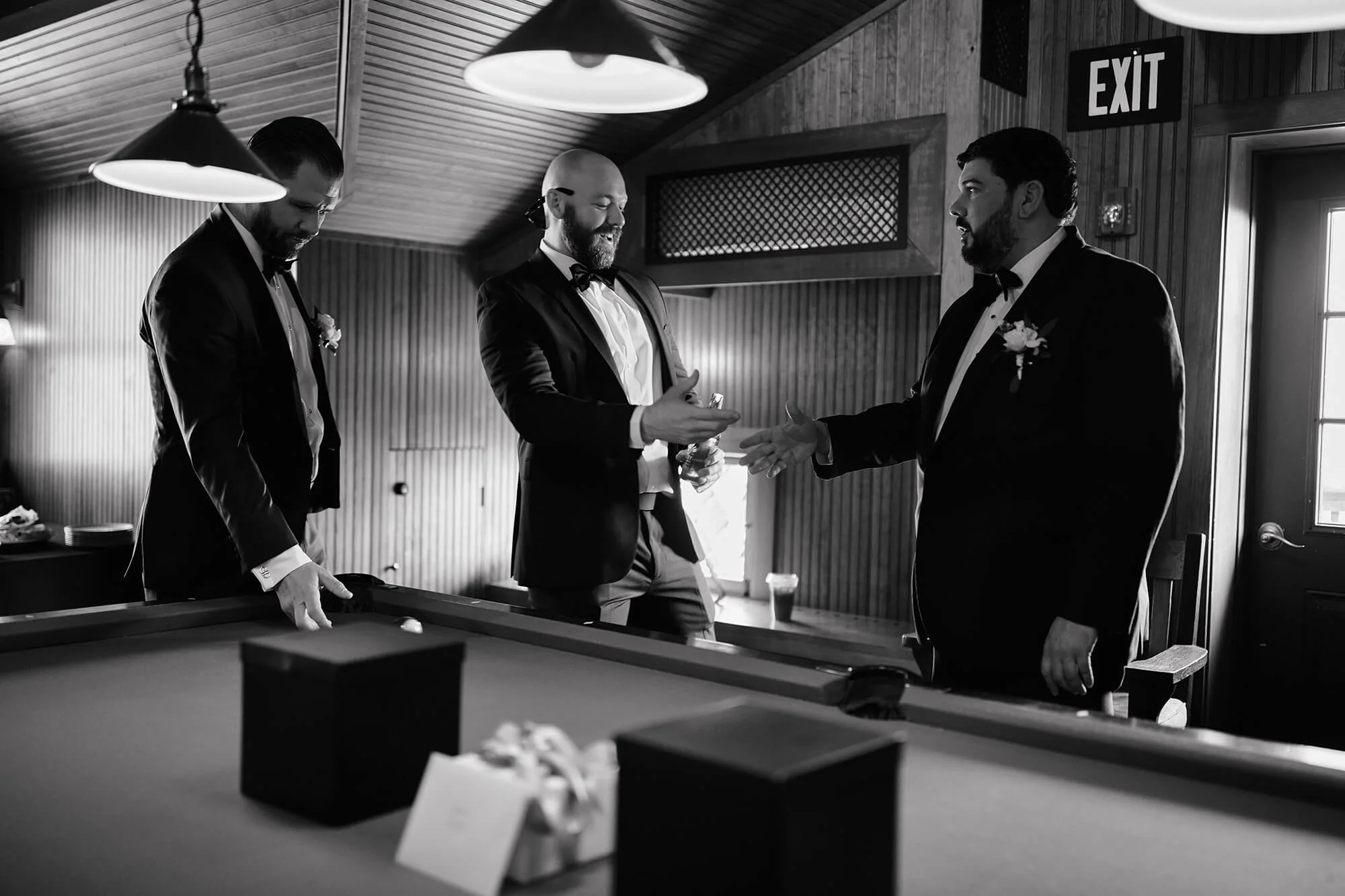 Groomsmen helping with details in a warm-lit space