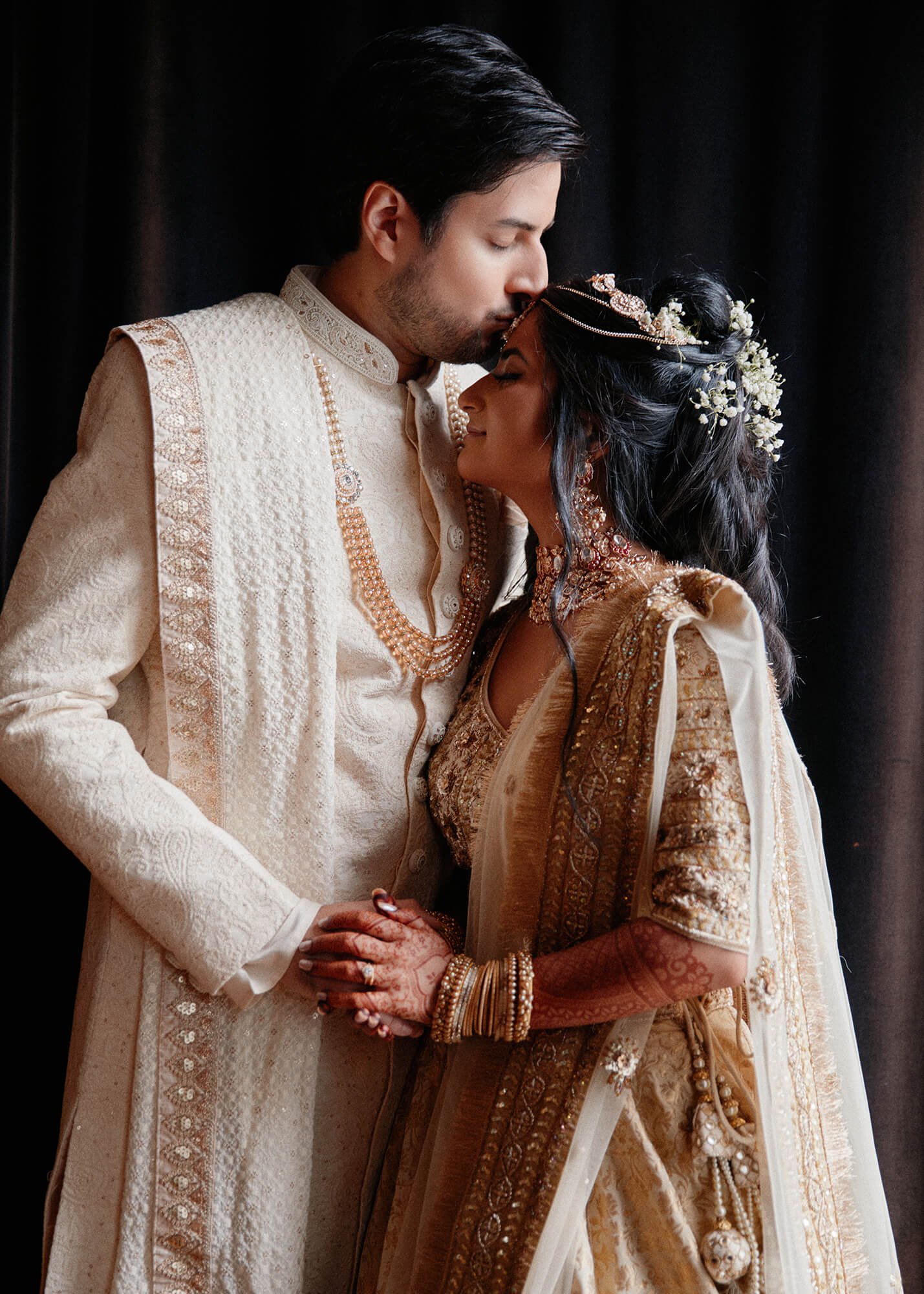 The bride and groom are in a tender moment during their ceremony.