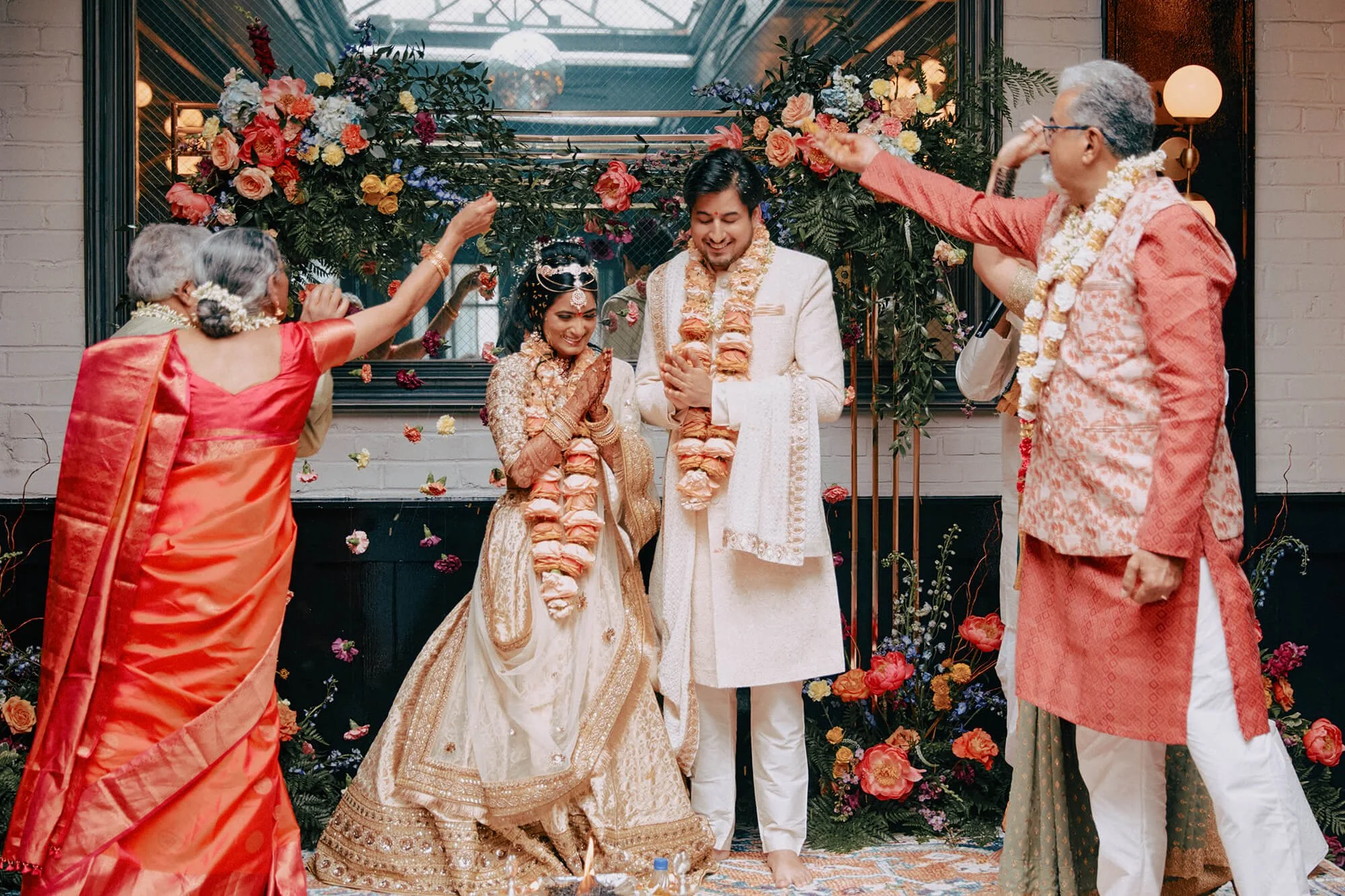 Bride and groom during a traditional Indian wedding ritual with flower petals.