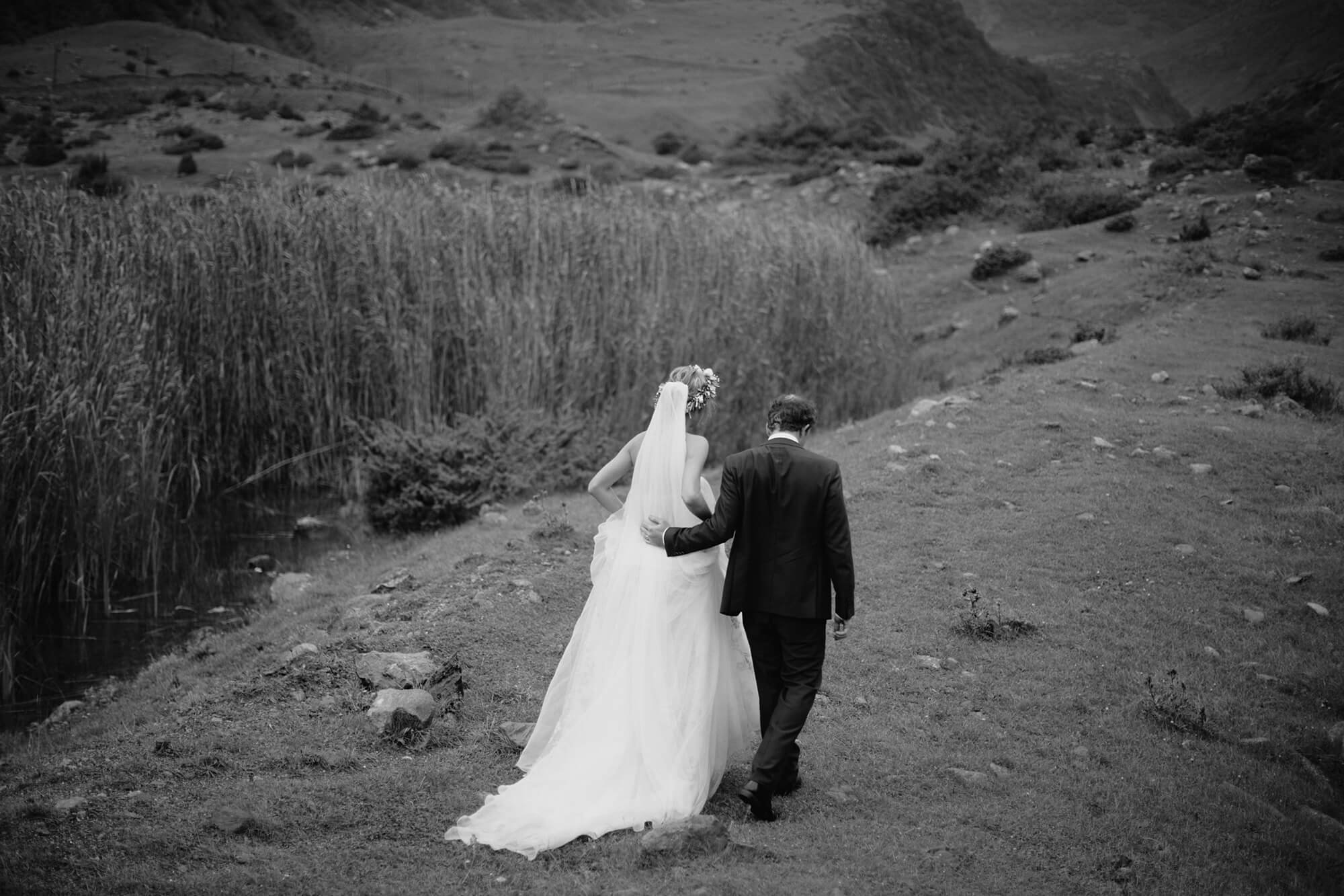 Bride and groom walk outdoor at Kazbegi mountains