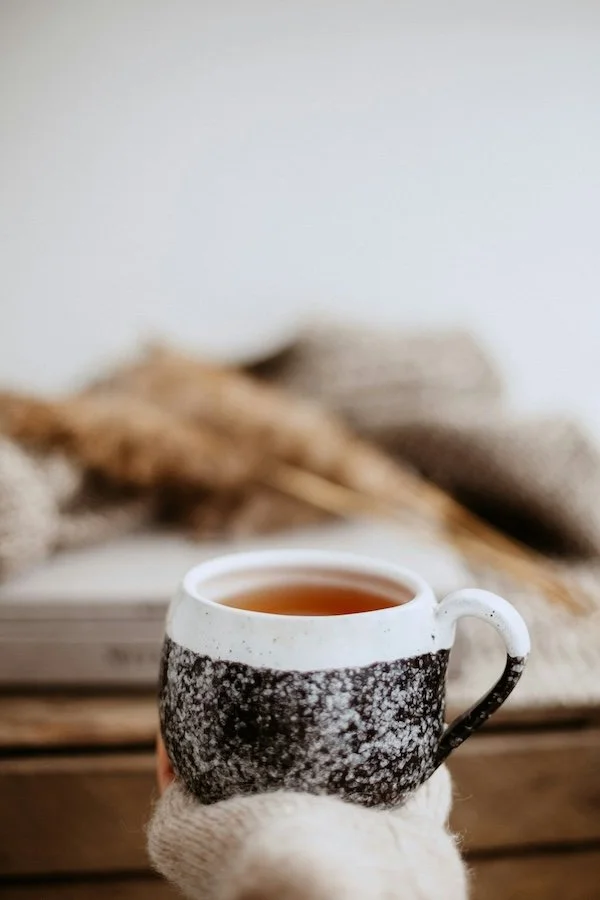 Cup of herbal tea beside a notepad outlining Remedy’s three-step naturopathic approach, symbolizing calm, thoughtful, and tailored care