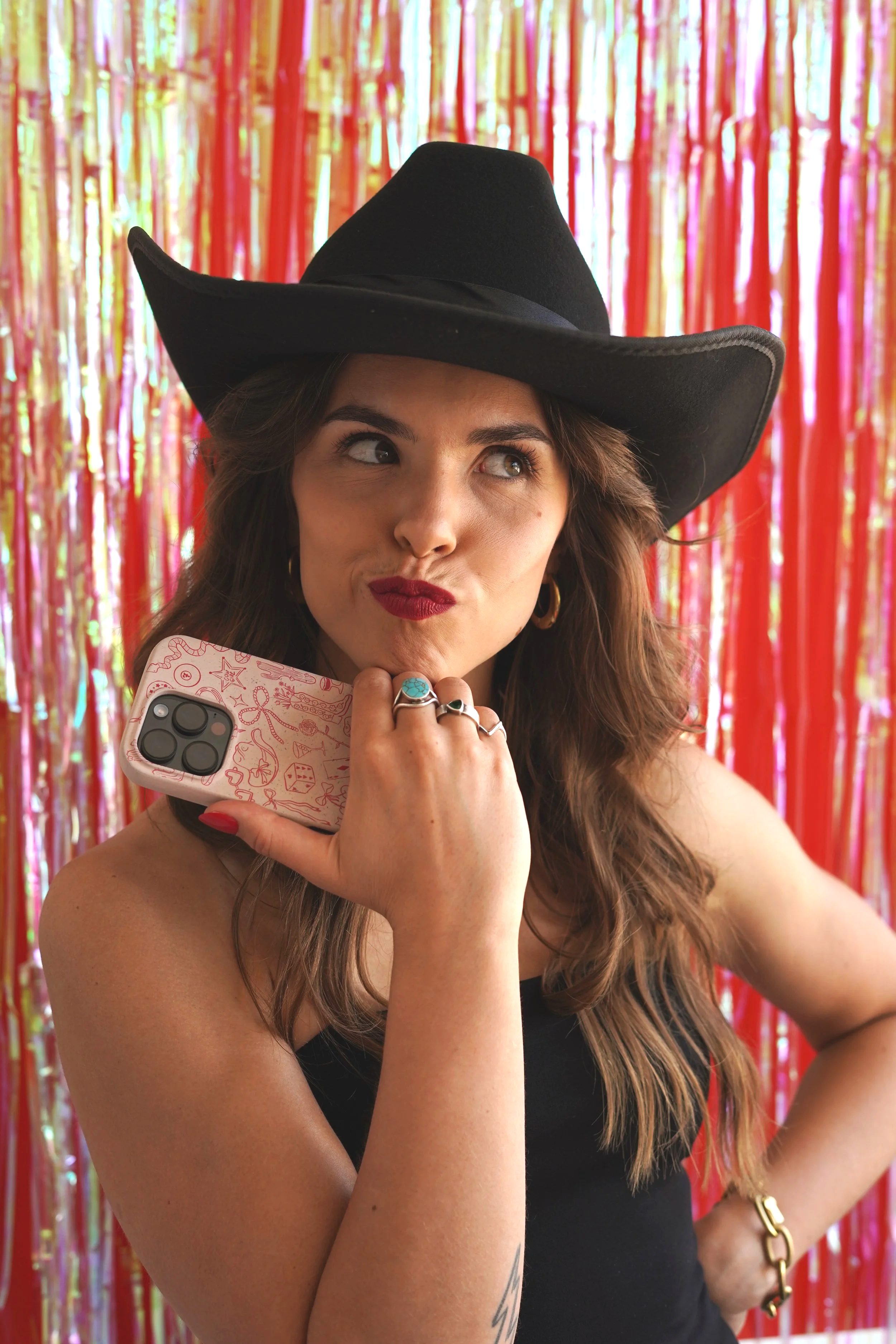 The Content Cowgirl with a thinking face, resting her chin on her hand with a phone in it.