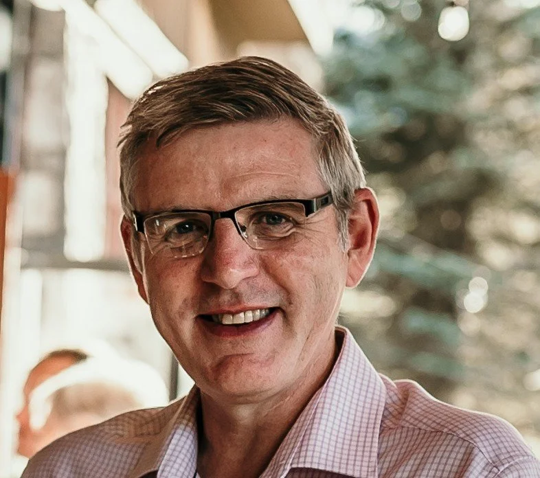 Man with glasses smiling outside