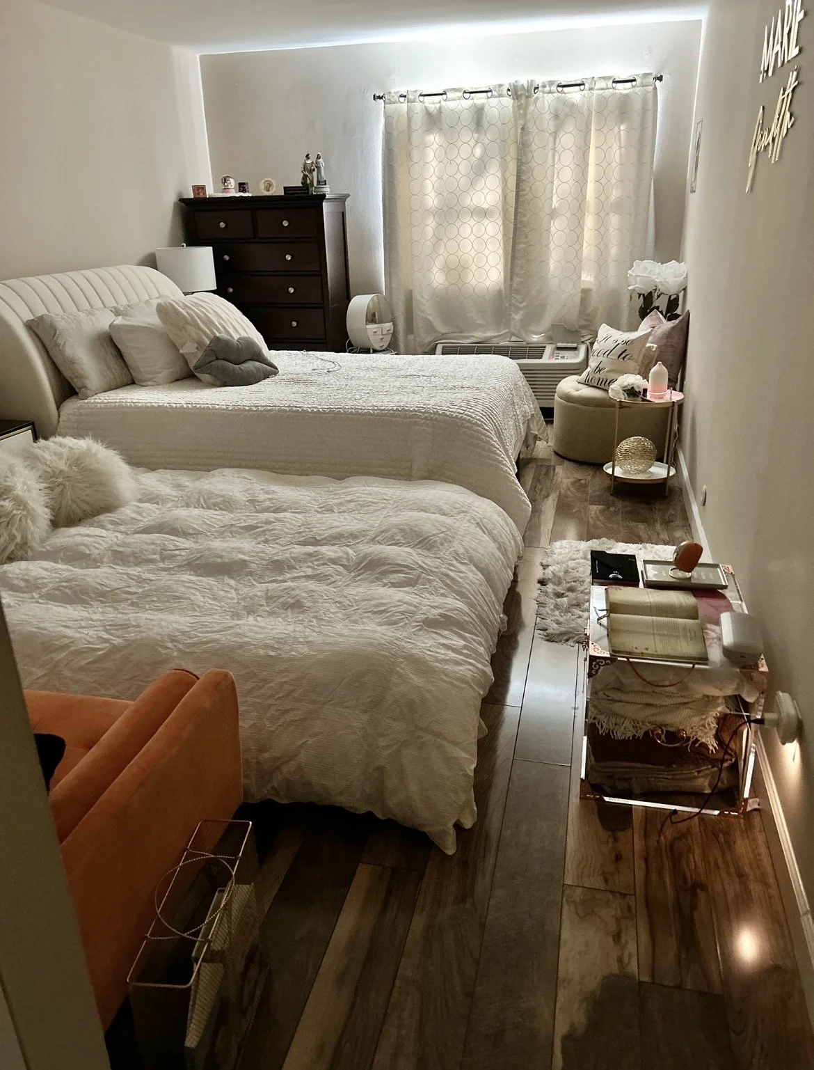 An acrylic trunk adds storage without visual heaviness, helping this redesigned bedroom feel open, airy, organized, and guest-ready.