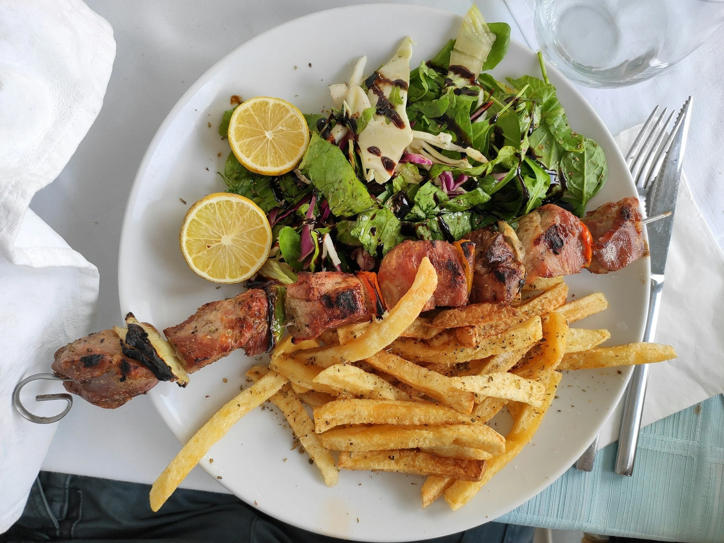 Plate of French fries, grilled meat skewers, green salad with lemon wedges, cheese, and balsamic vinegar, Free Souvlaki, Takeaway, Pavlos Greek Busselton