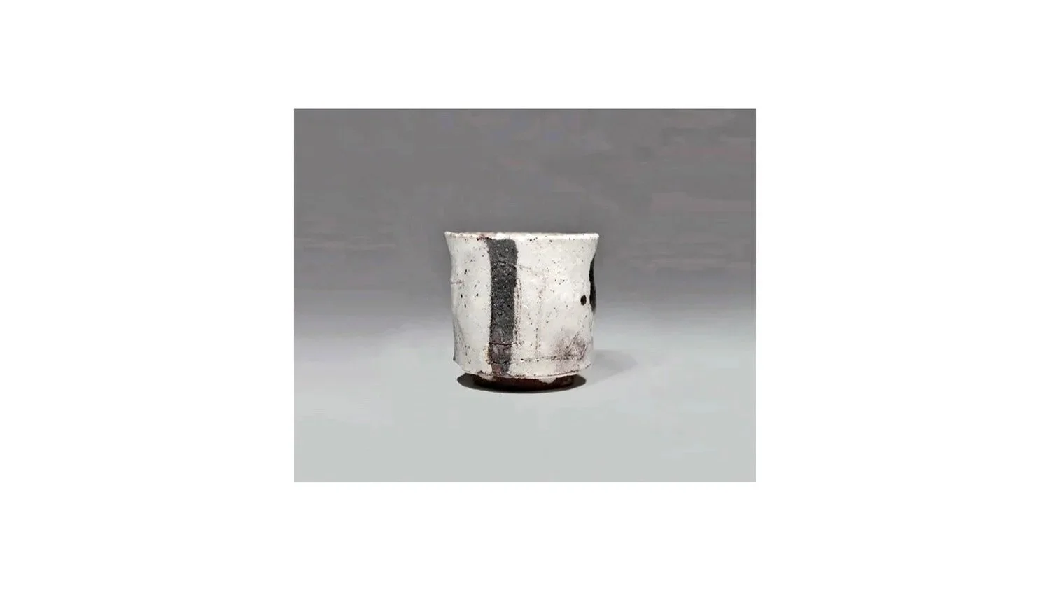 Koei Ryoji (1938-2000). White sake cup, stoneware with black iron-oxide glaze, H 5.3 cm x W 5.3 cm.