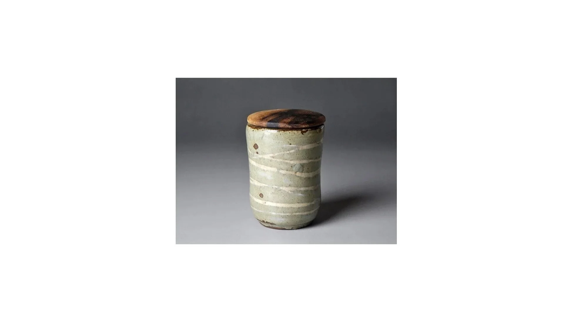 Nakamura Kohei (b. 1948), tea caddy with flowing design, stoneware with greenish and cream-colored glaze, H 6.8 cm x W 5.1 cm. 