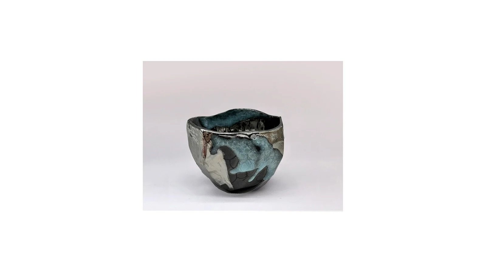 Imanishi Hirotake (b. 1984), Black tea bowl with blue and metallic glazes, H 10 cm x W 11 cm.  