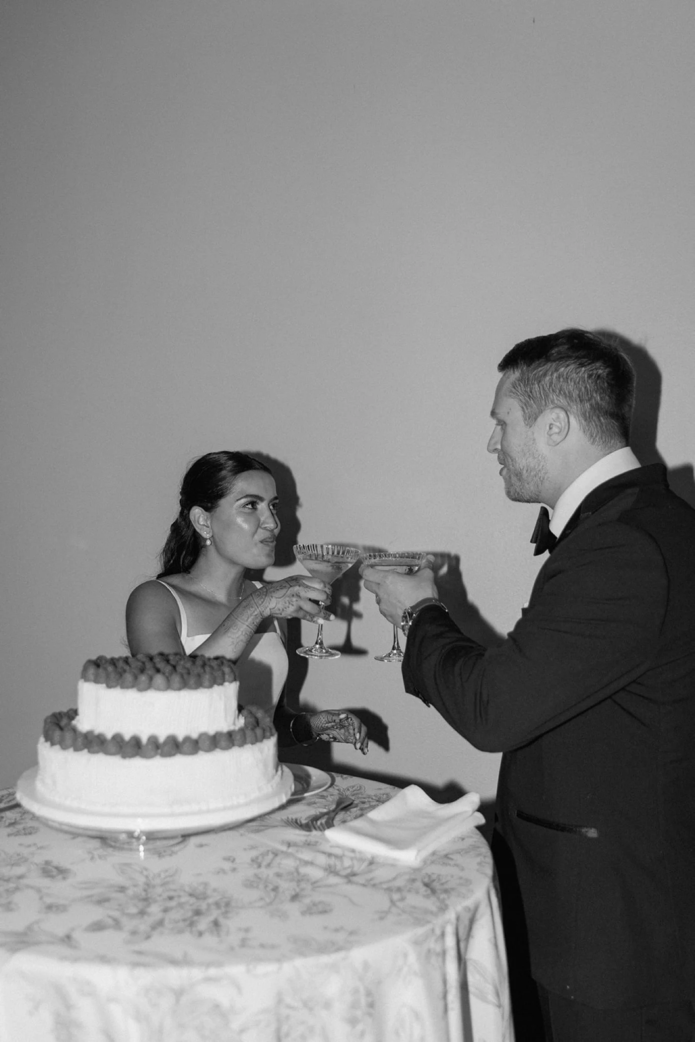 Bride and groom toasting with champagne after cutting their wedding cake