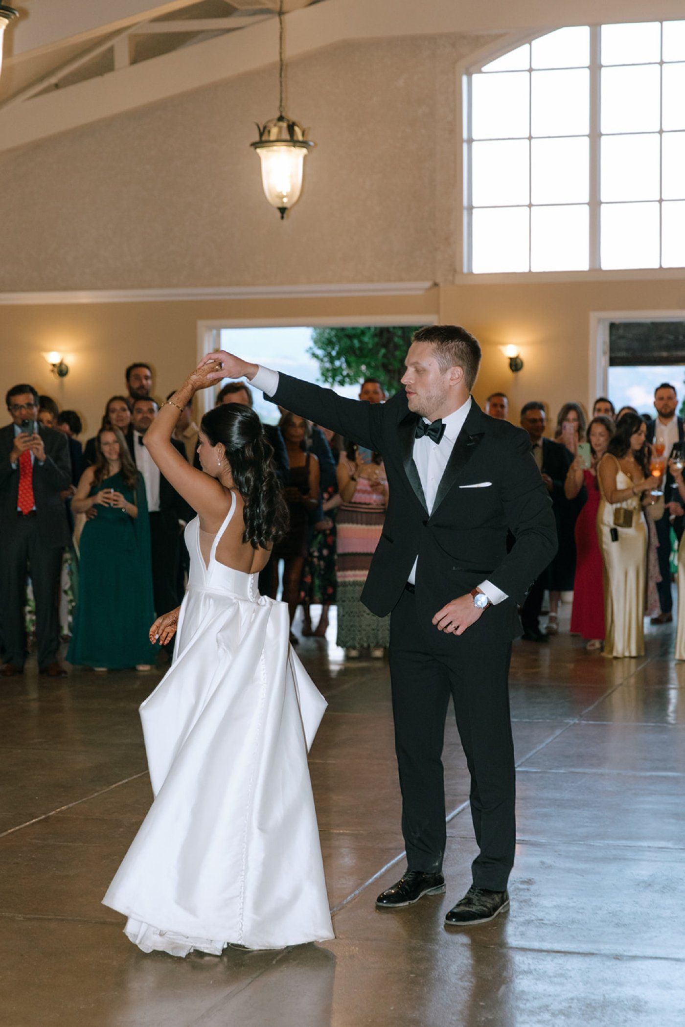 Groom twirling his bride during their first dance
