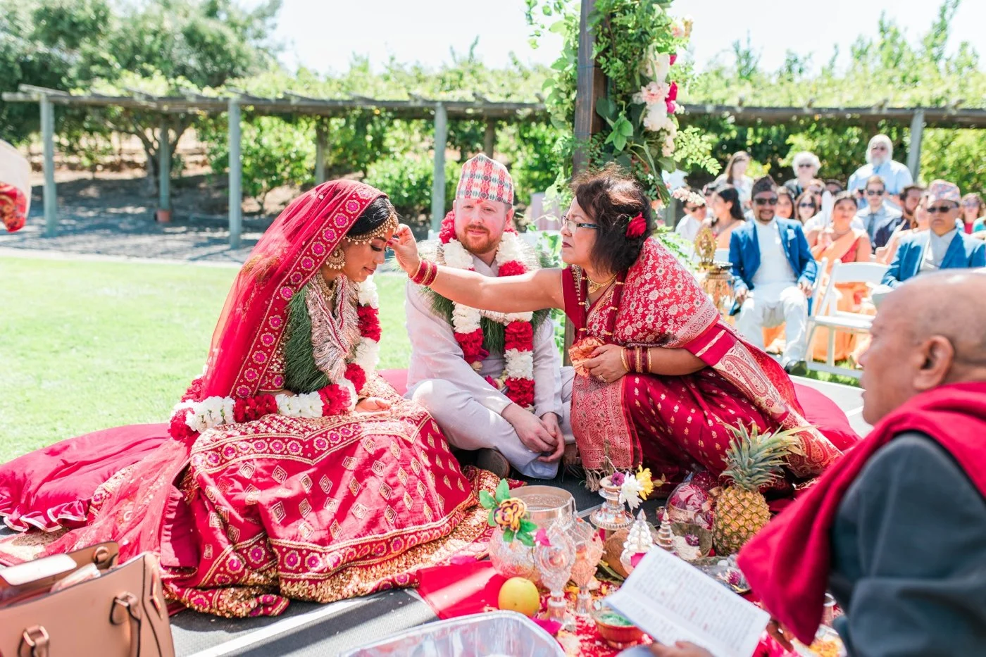 Bride receiving a tilak on her forehead during her Hindu wedding ceremony