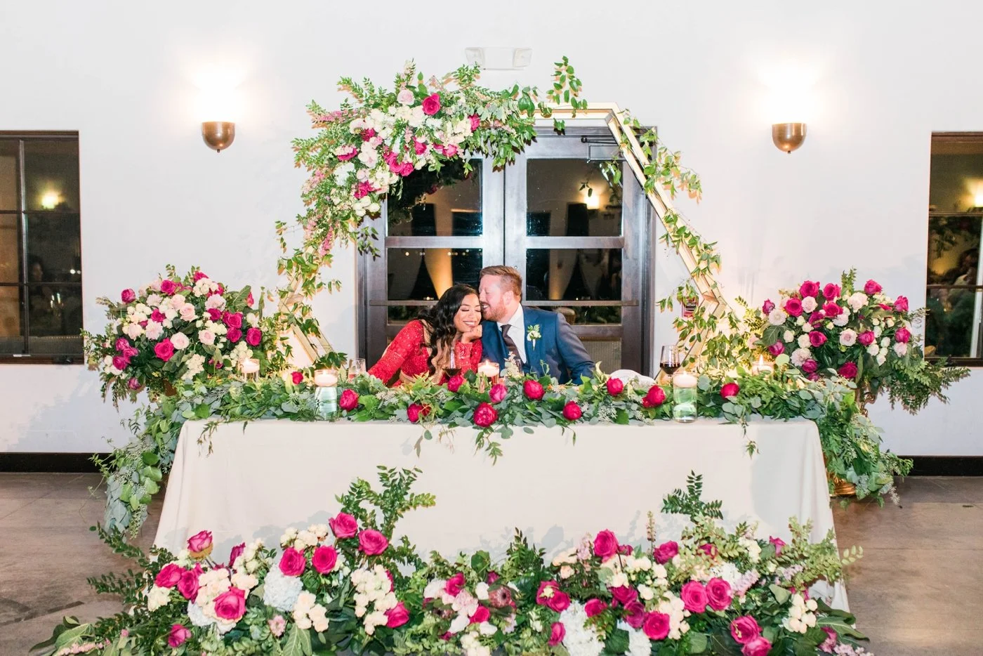 Groom whispering in his bride's ear during dinner at their wedding reception
