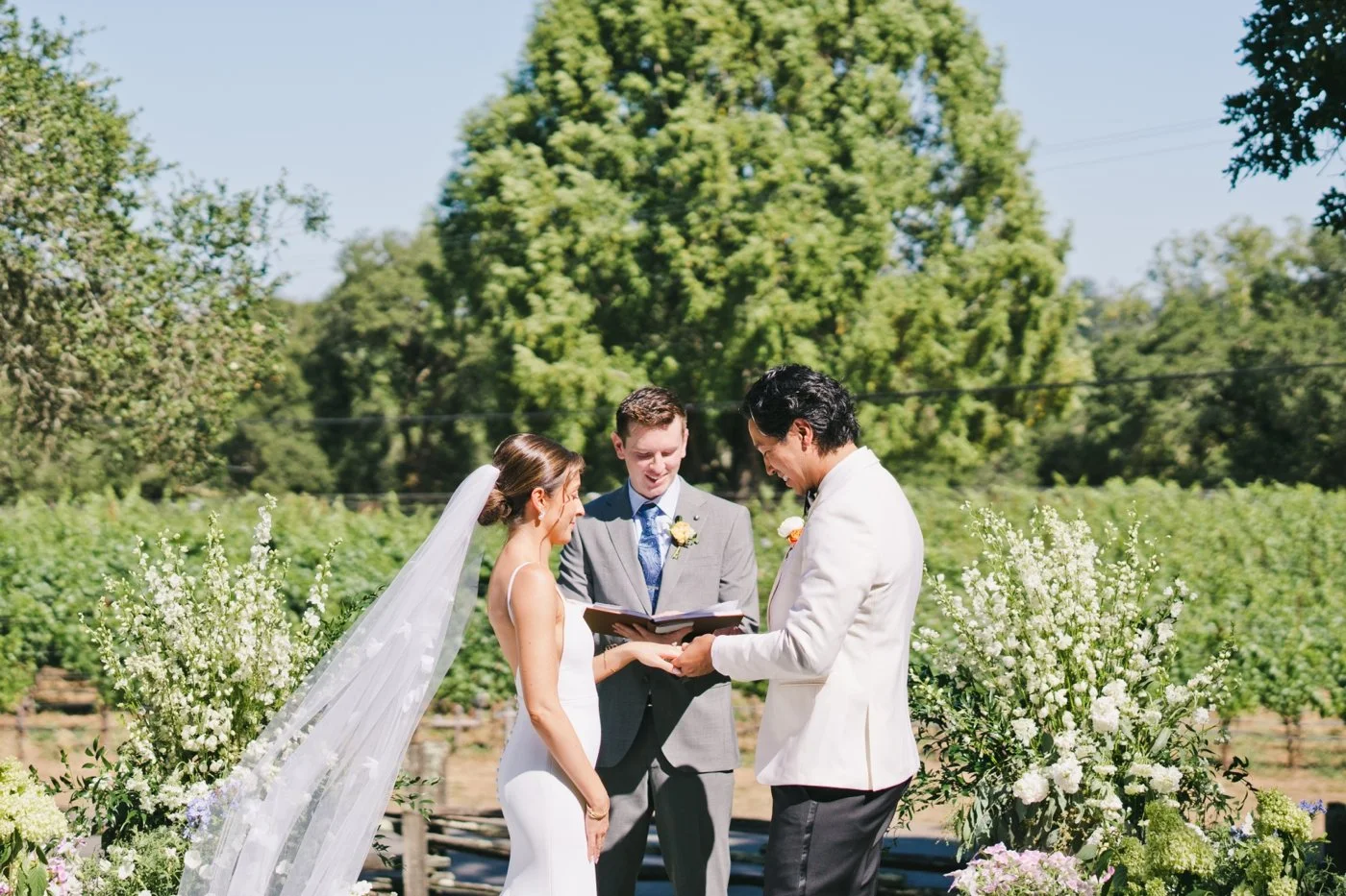Groom putting a wedding band on his bride's finger during their wedding ceremony