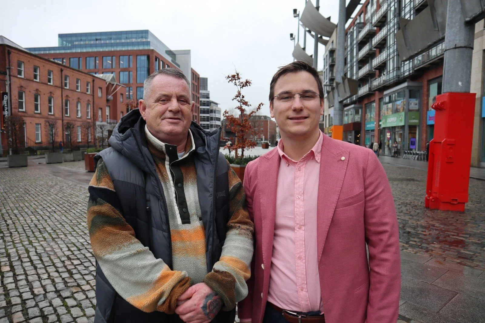 Silhouettes of five people on a mountain cliff during sunset, with some helping each other and sharing a high five for teamwork and unity.