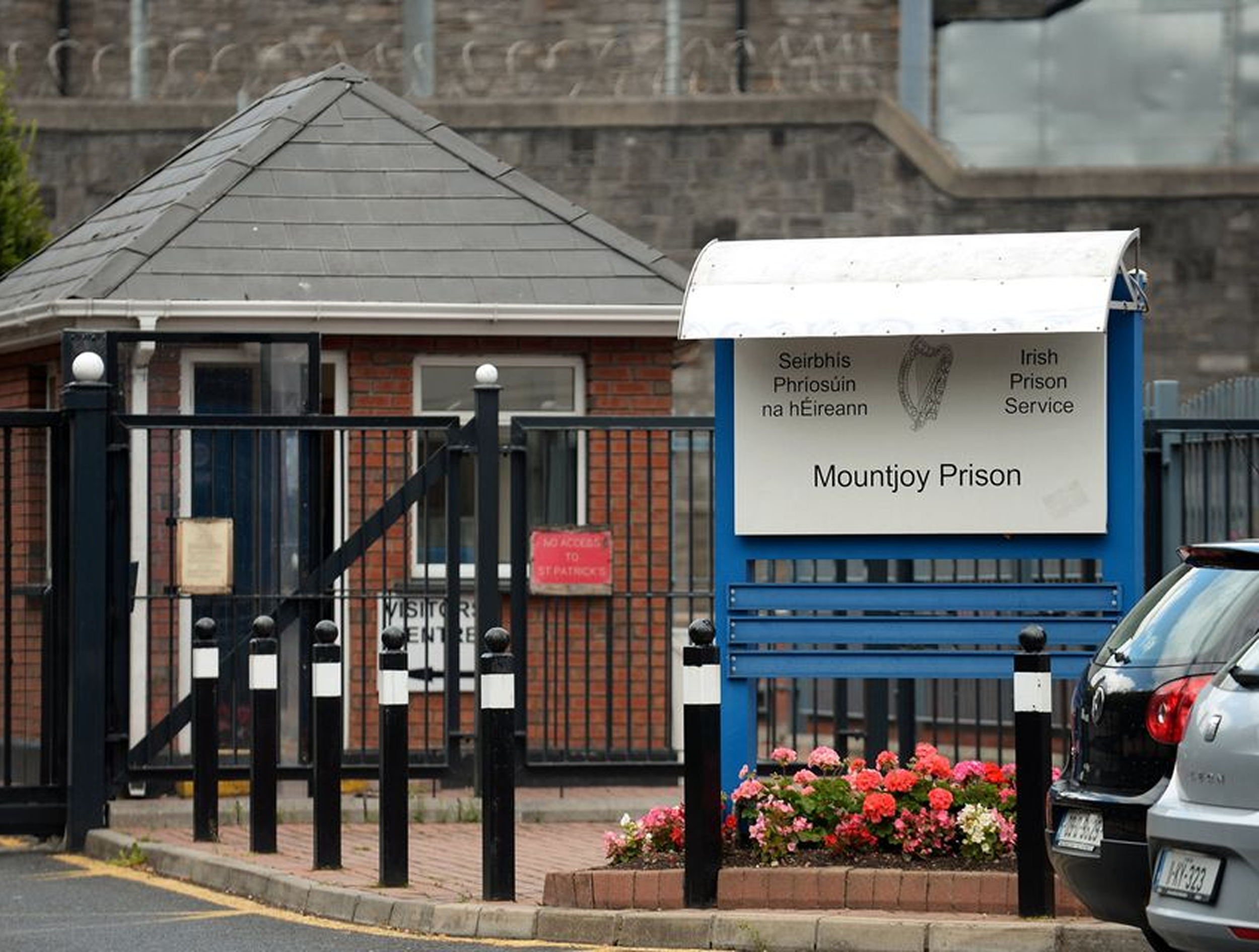A diverse group of eight people sitting around a wooden table in a meeting or discussion, with documents, tablets, and notebooks, and a small green plant in the center.