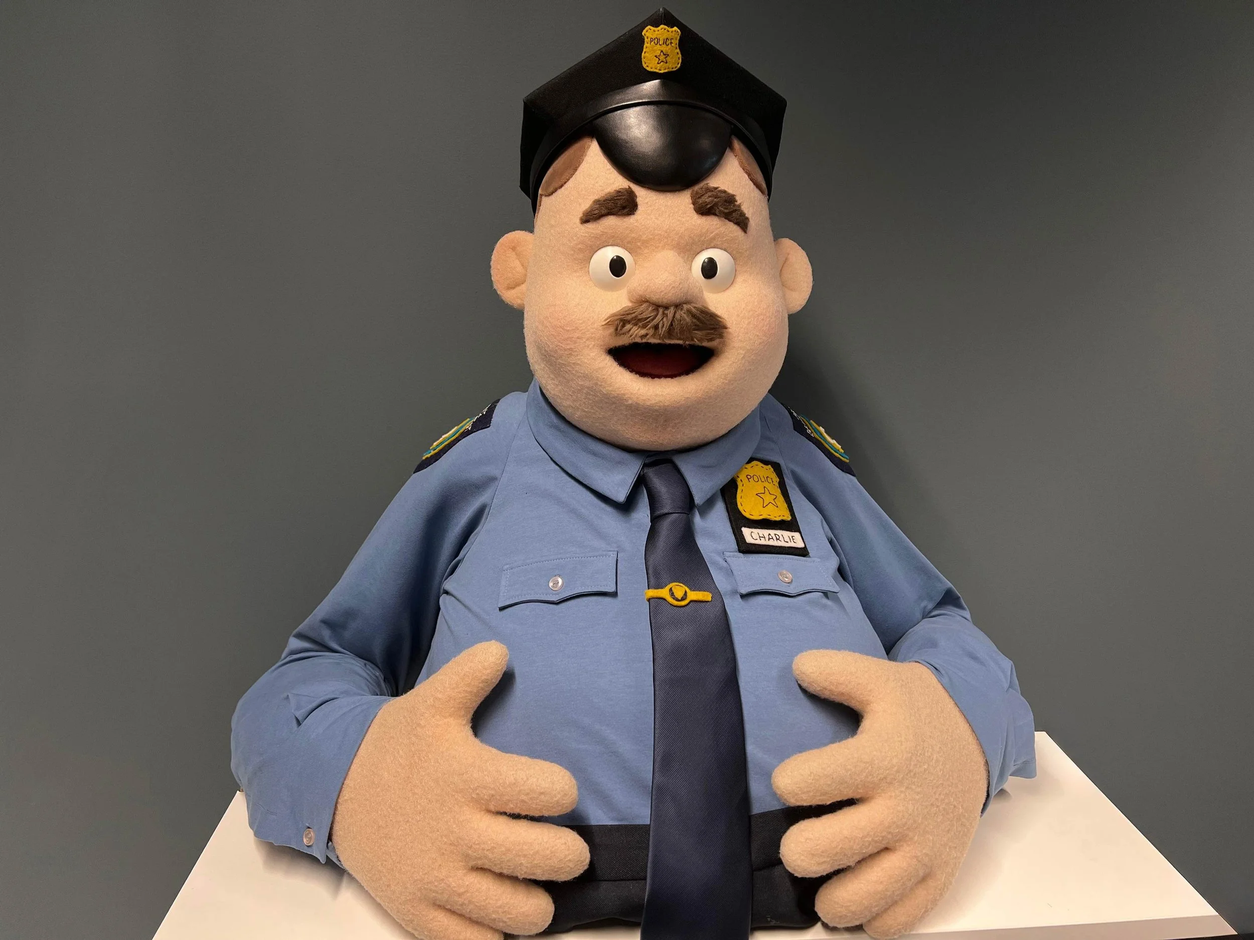 A mascot character dressed as a police officer created by Stitches & Glue puppet makers