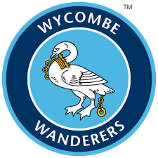 WYCOMBE WANDERERS logo featuring a white swan with a gold ring in its beak and a gold ring on its leg, inside a blue circular badge.