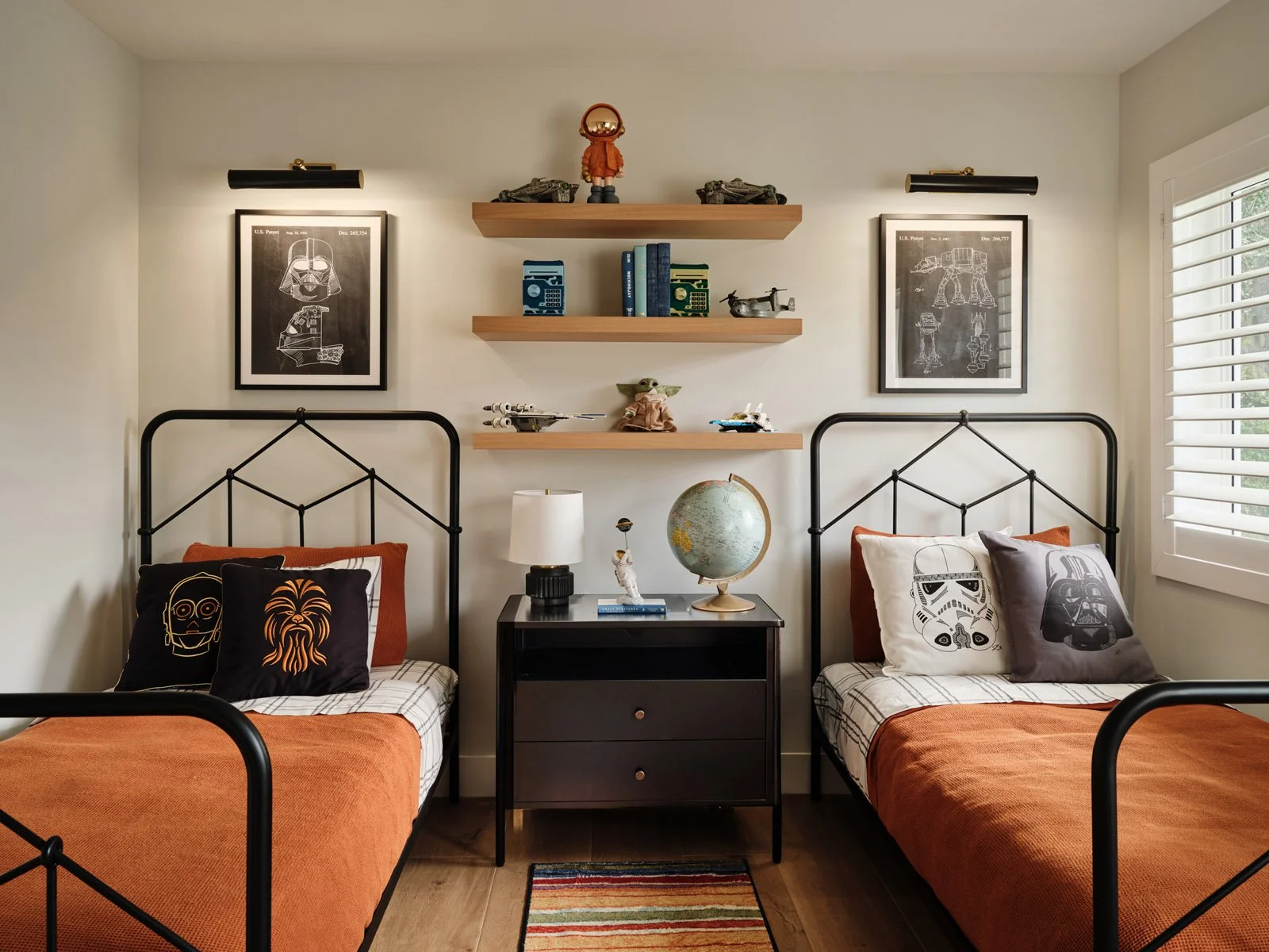 Kids bedroom with twin iron beds, rust bedding and wall shelves