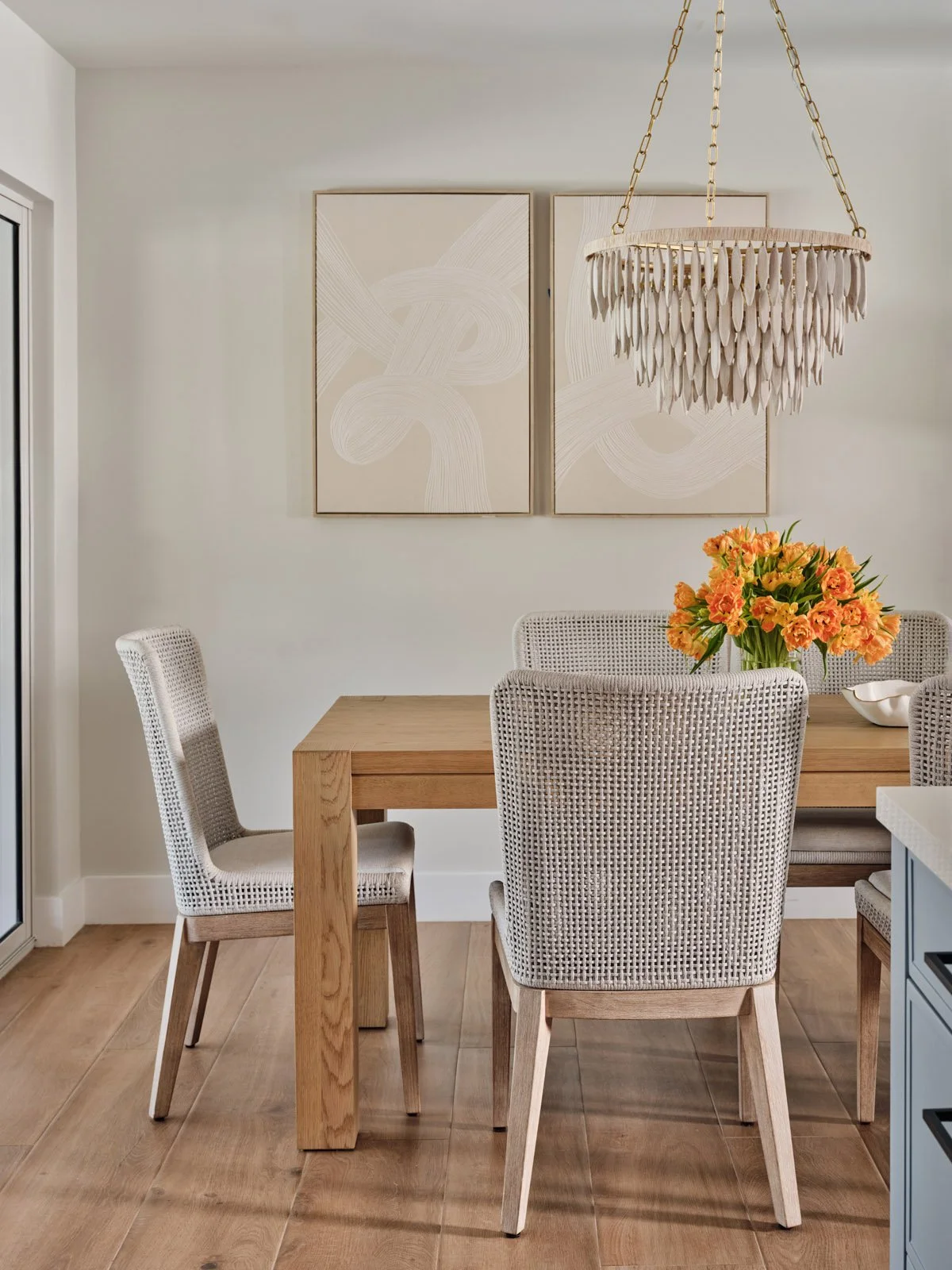 Dining nook with wood table, striped chairs and bead chandelier
