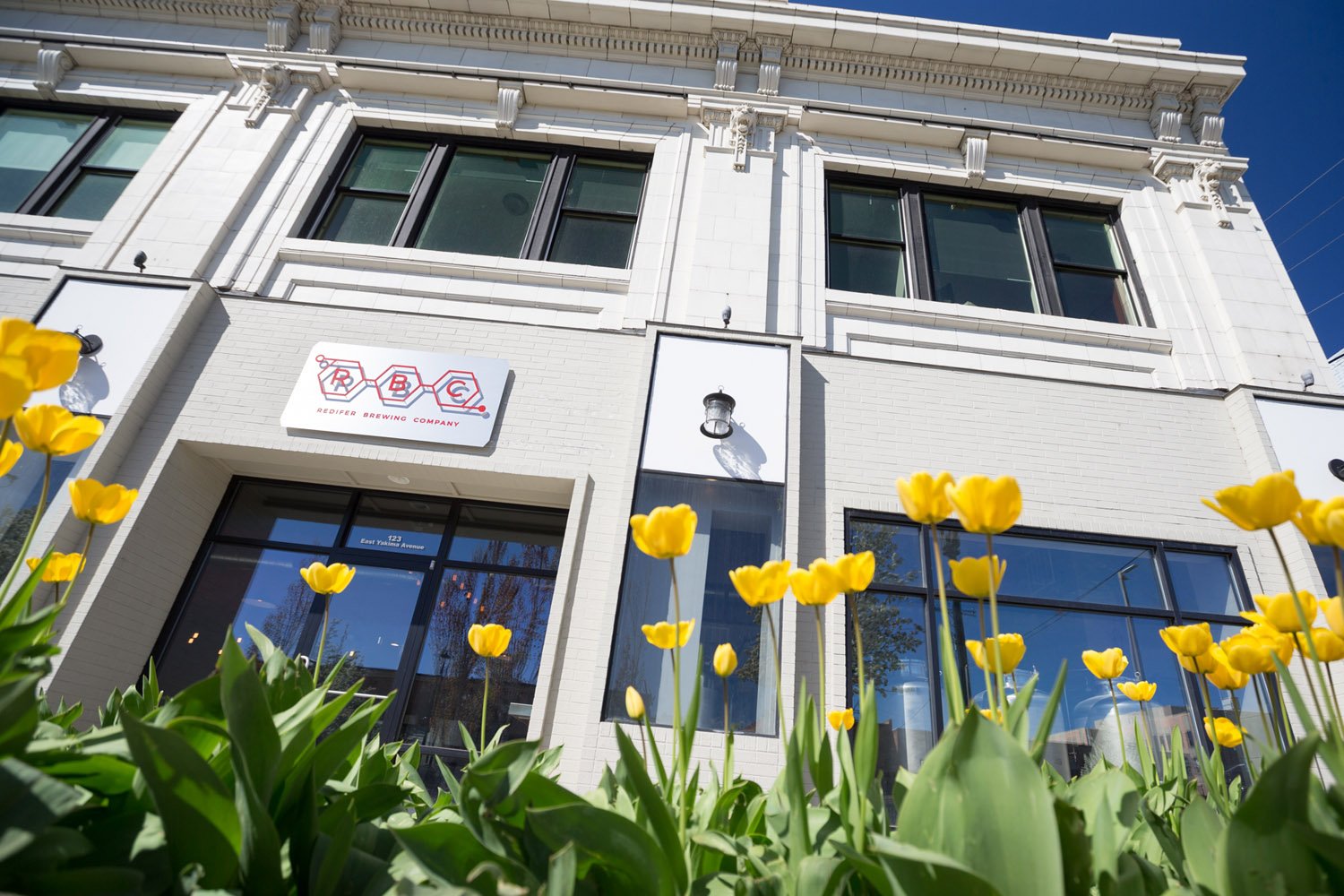 Brewery building exterior with yellow tulips in the foreground