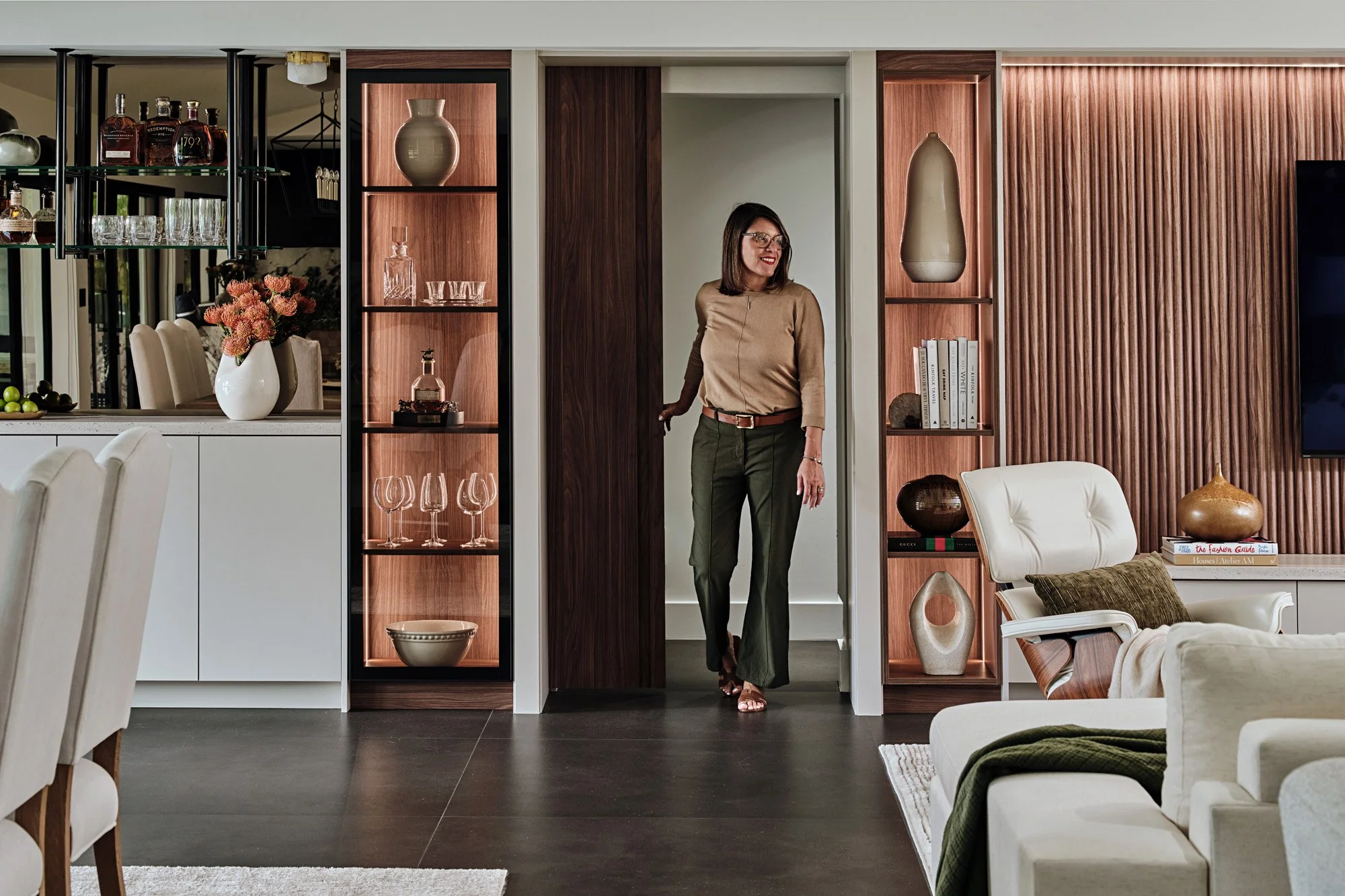 Living area with walnut pocket door and lit display shelves