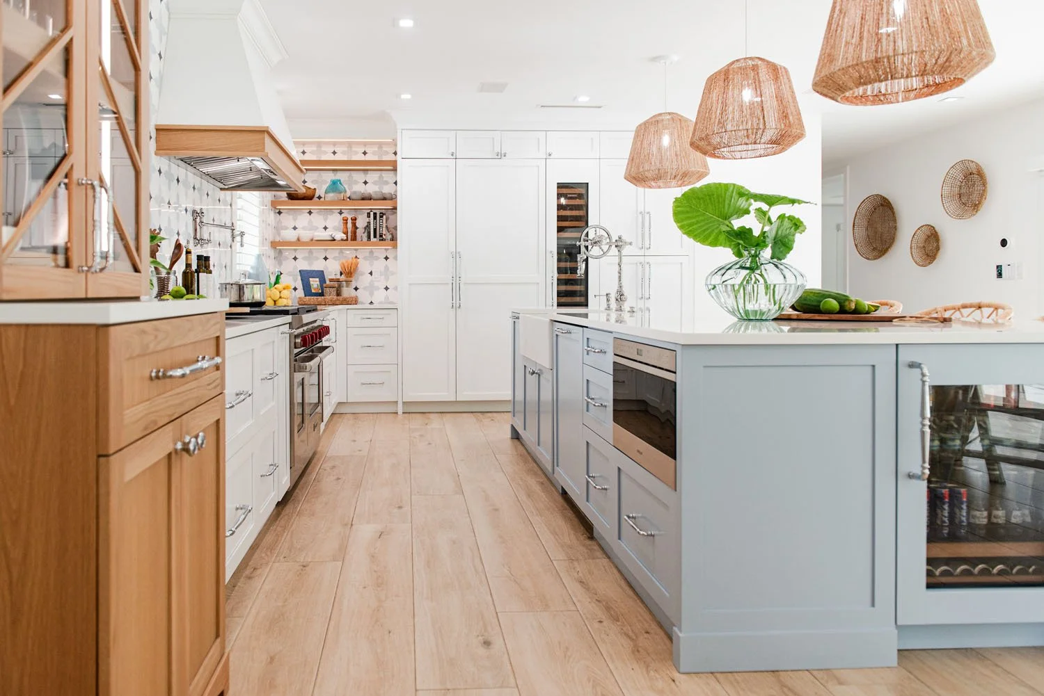 Long view of kitchen with light blue island and wood cabinetry