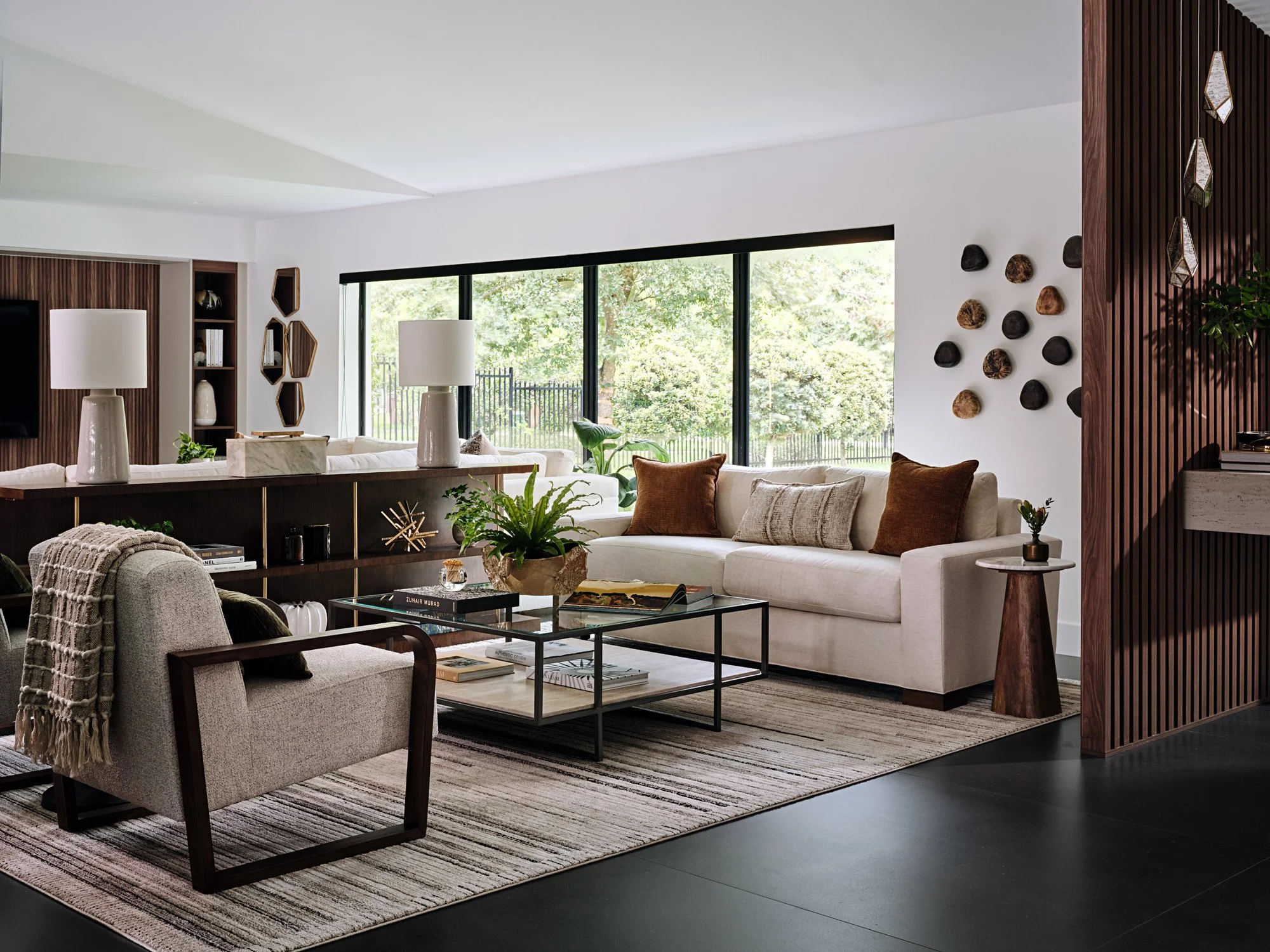 Living room with cream sofa, black armchair and tall windows