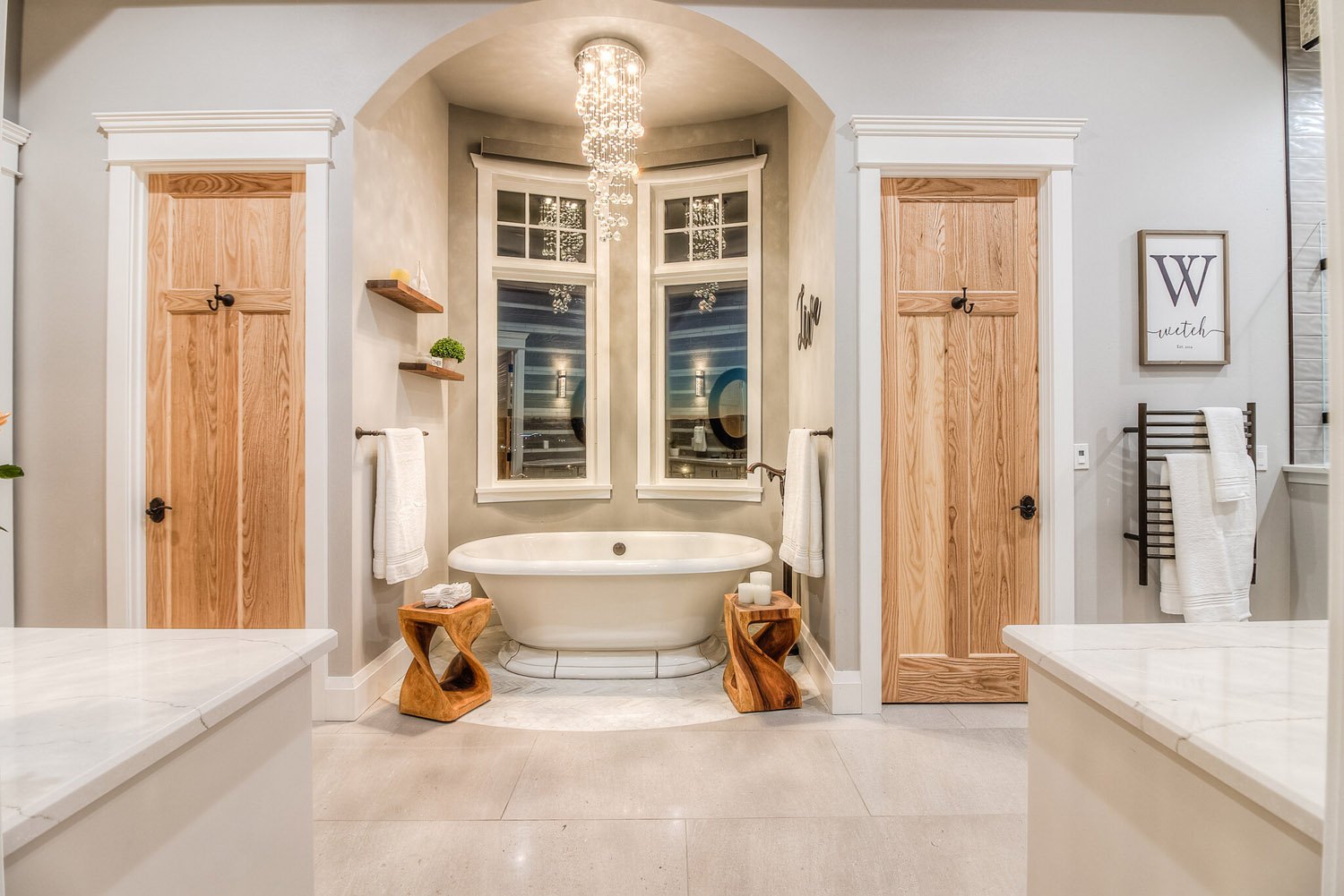 Freestanding tub under a window with wood doors on each side