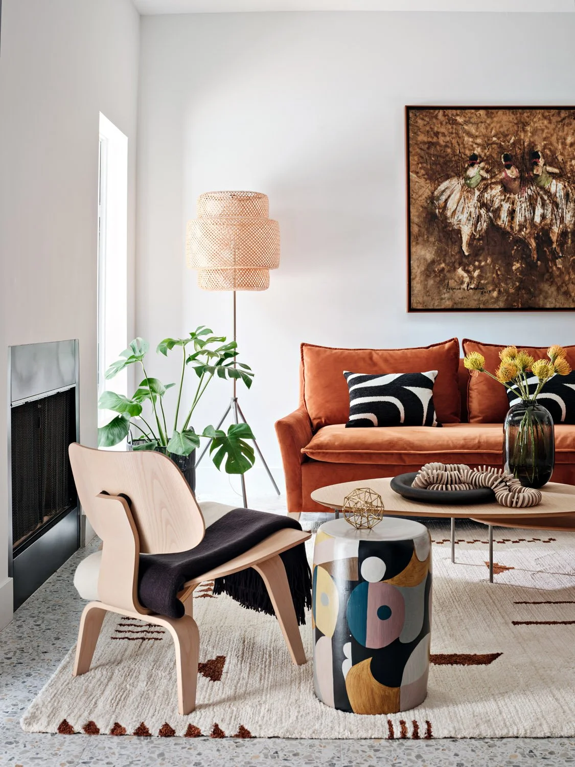 Living room with rust velvet sofa, molded plywood lounge chair and patterned rug