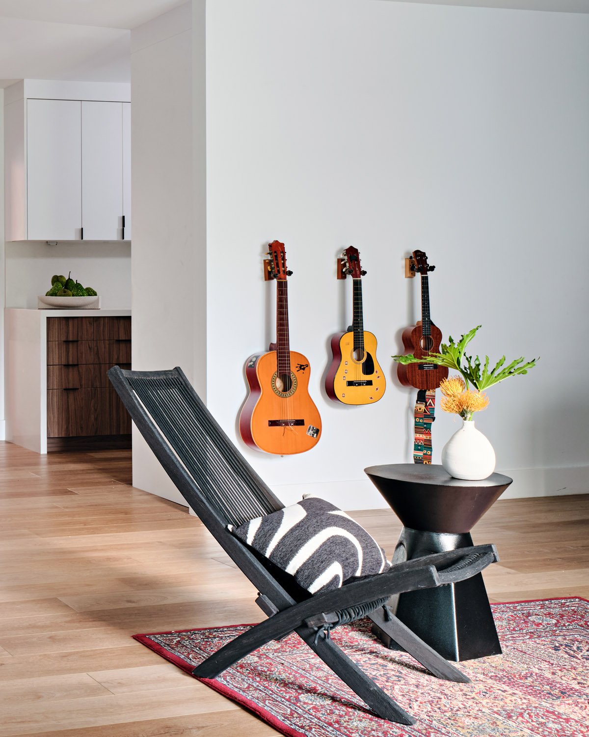 Black folding chair and side table with guitars on the wall
