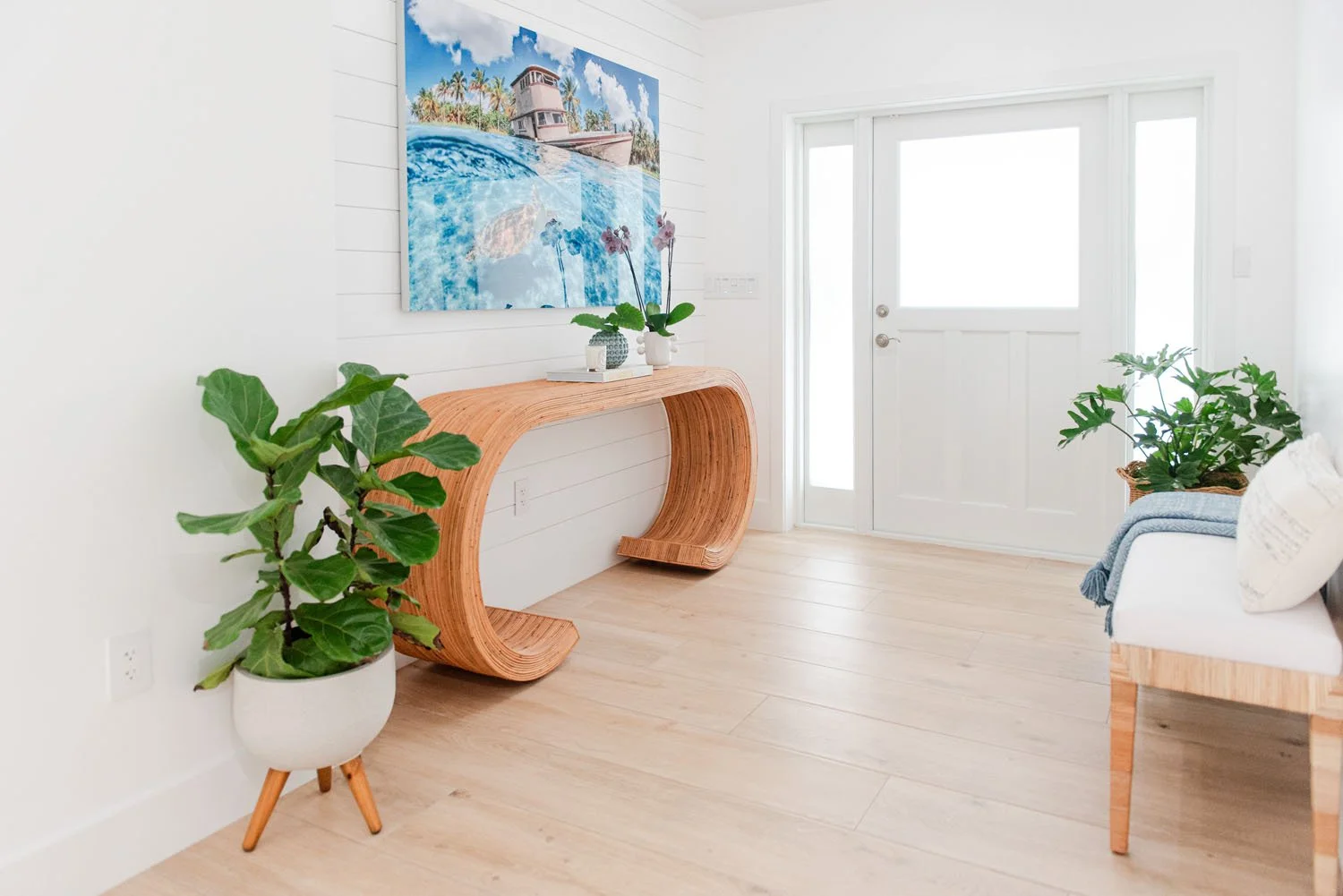 Entry with wavy wood console, blue artwork and fiddle leaf fig