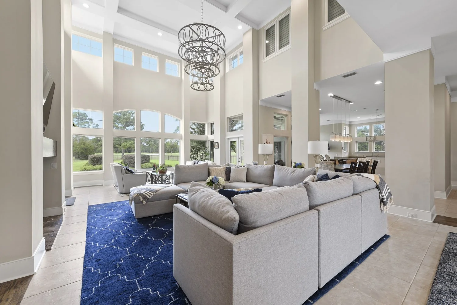 Two-story great room with sectional, chandelier and arched windows